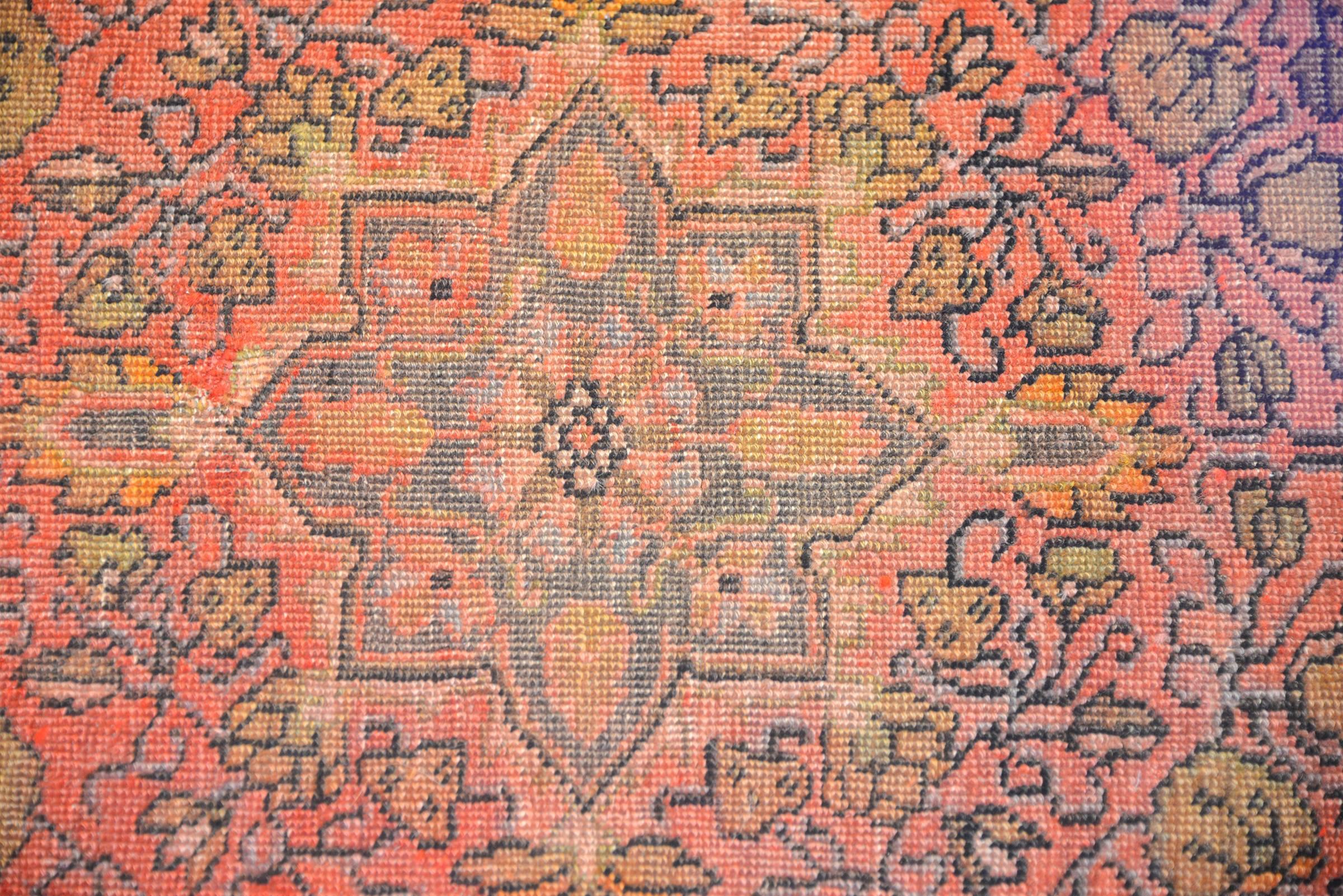 An amazing circa 1920 Persian Sarouk Farahan rug with a wonderfully stylized floral pattern woven with natural vegetable dyed wool. The large eight-lobed floral medallion lives on a pale crimson field of multicolored flowers and vines. The border is