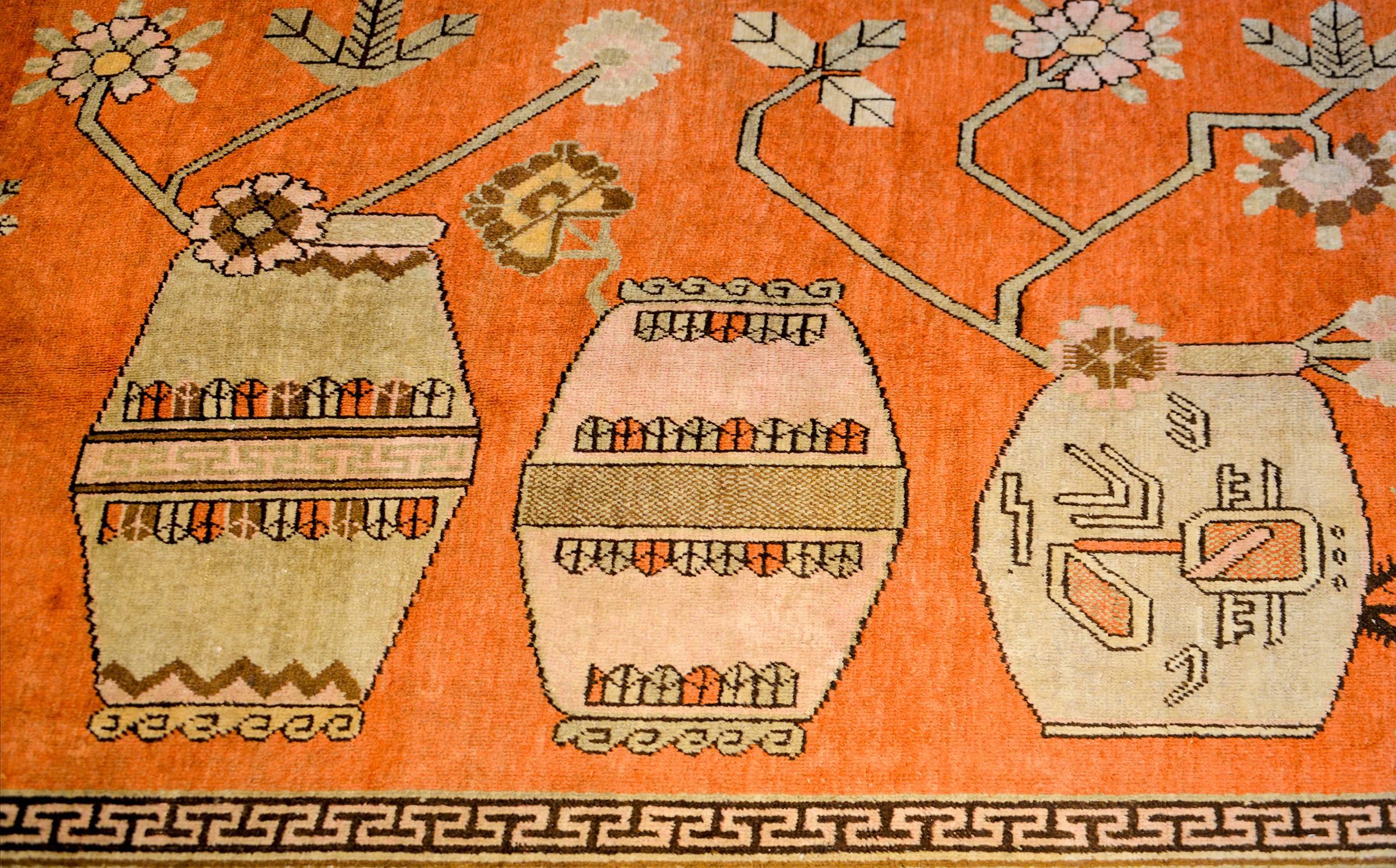 A wonderful early 20th century Central Asian pictorial Khotan rug with five large-scale Chinese-style vases potted with auspicious peony blossoms, and woven in multicolored vegetable dyed wool. The border is fantastic with a stylized large-scale