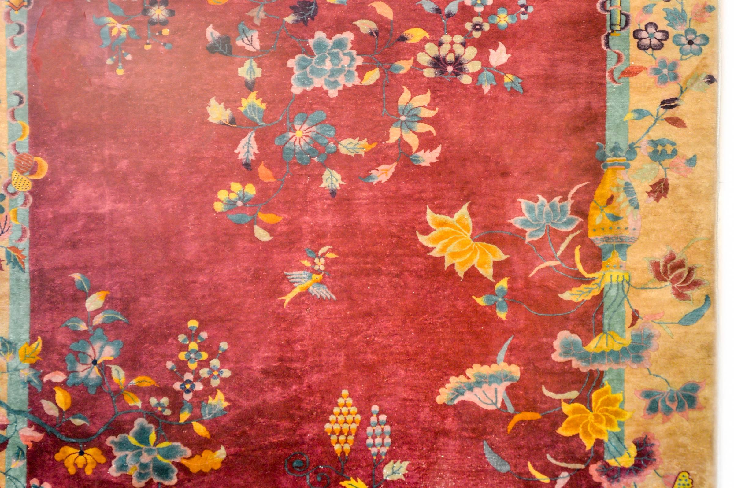 An exceptional early 20th century Chinese Art Deco rug with a beautiful deep cranberry background, and a pale gold border. There are myriad multicolored auspicious potted vases with auspicious flowers like chrysanthemums, peonies, lotus, and cherry