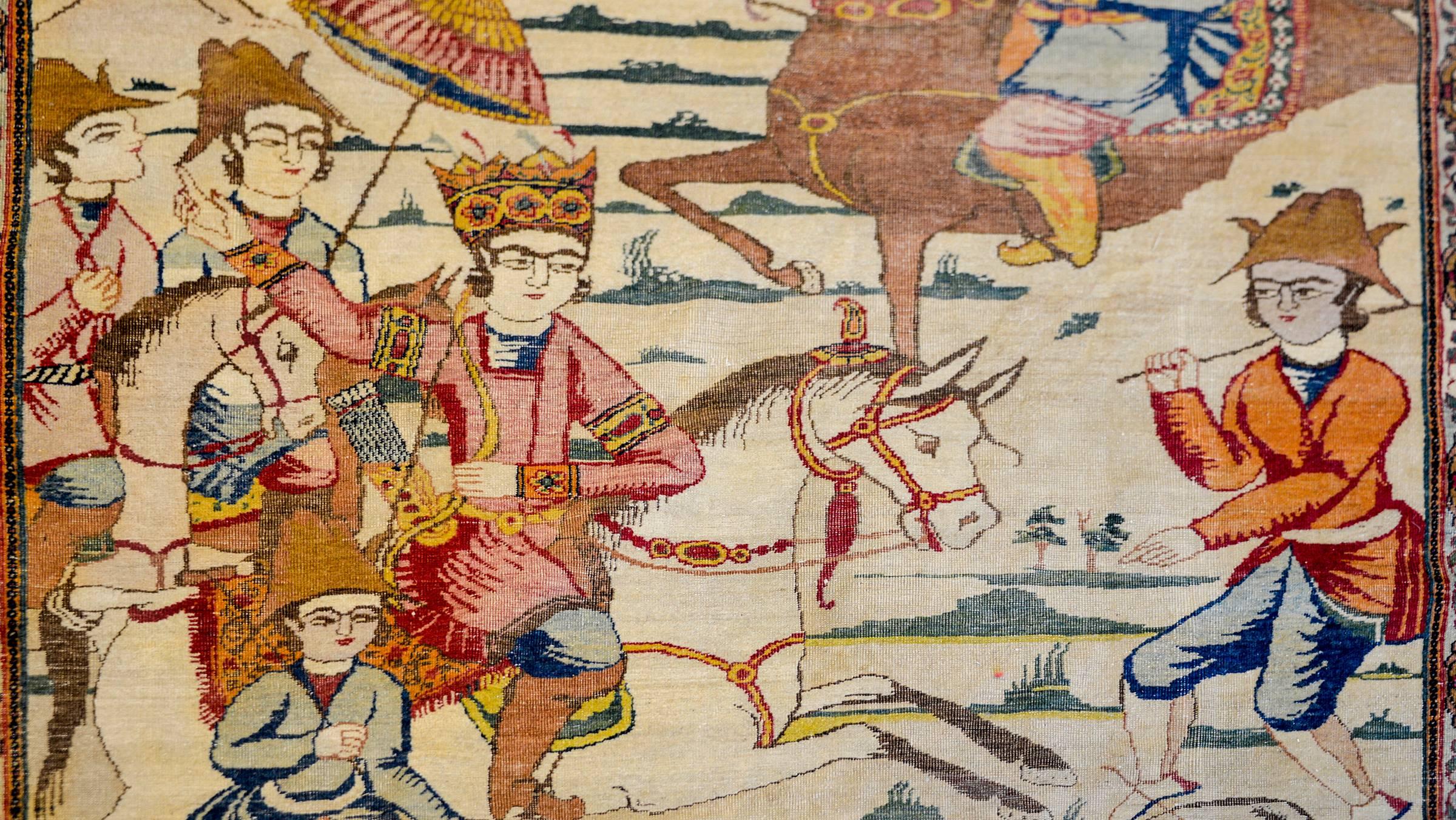 An incredibly important late 19th century Persian Pictorial Lavar Kirman rug depicting the 5th century Sassanian King, Bahram Gur, mounted on horseback and hunting a deer with bow and arrow, surrounded by several attendants. The rendering is