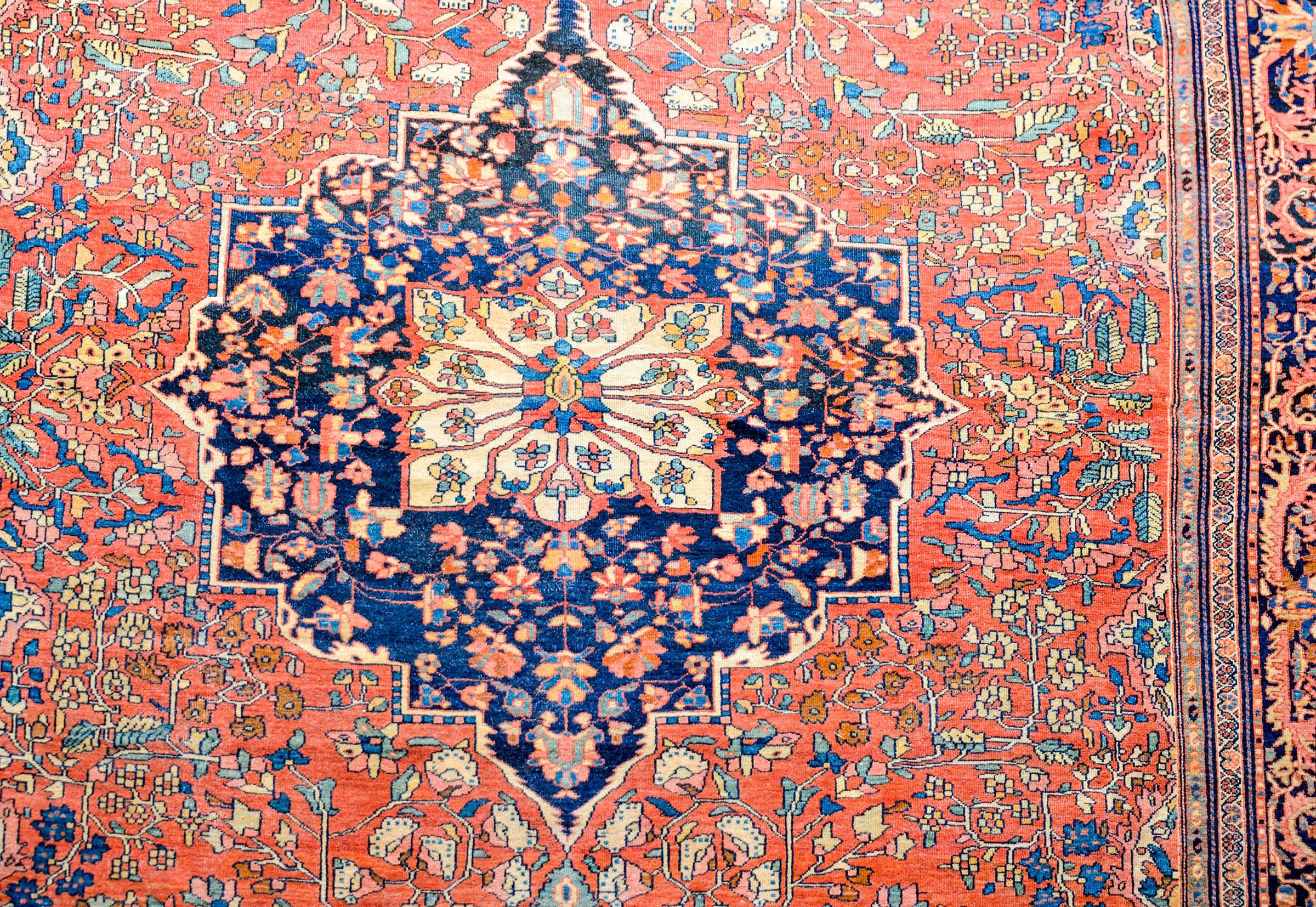 An extraordinary late 19th century Persian Sarouk Farahan rug with an incredible predominantly crimson color way. There is a large medallion on a field of intensely woven flowering vines, surrounded by a contrasting border with a large-scale floral