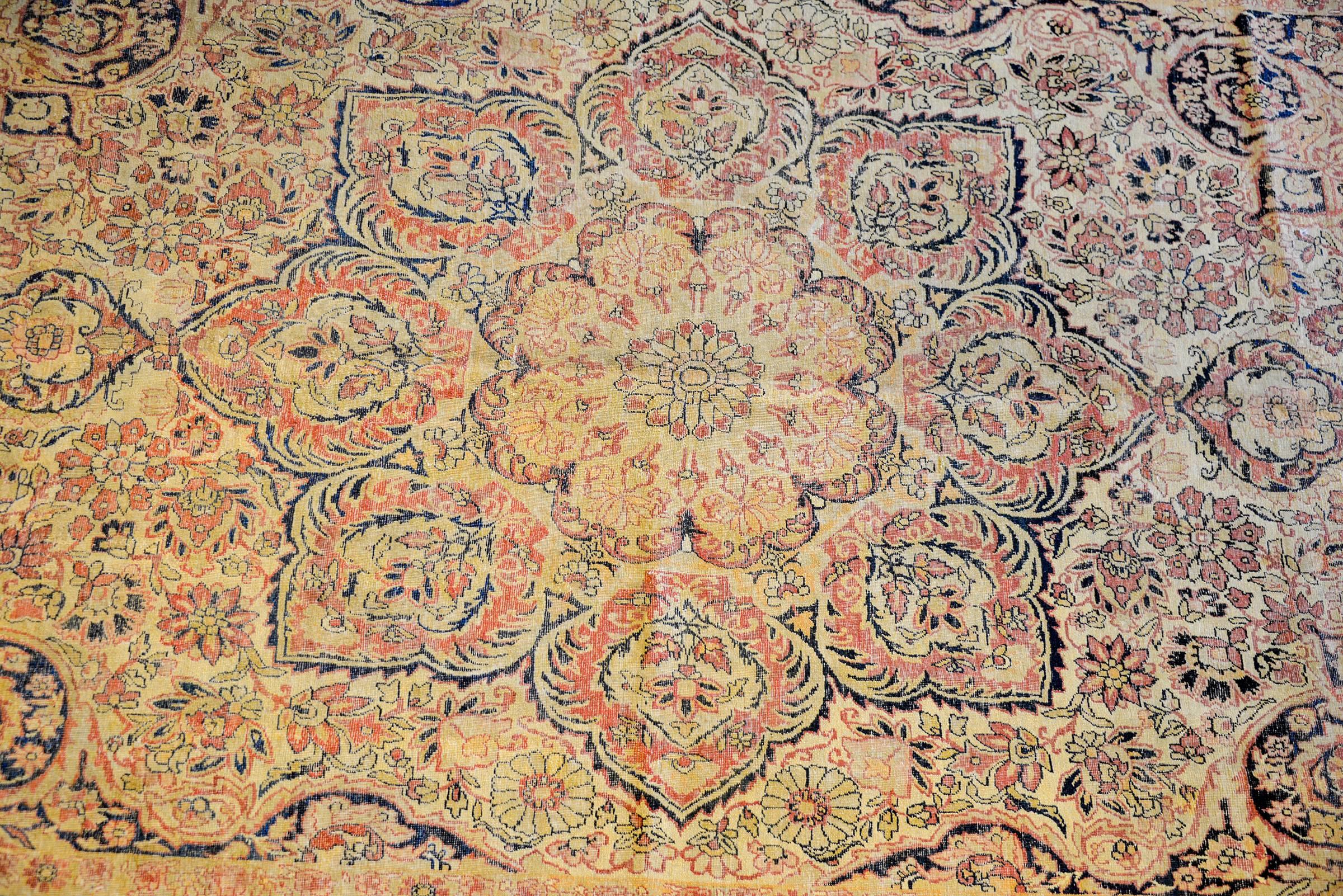 An extraordinary 19th century Persian Kermanshah rug with a large tightly woven eight-lobed floral medallion amidst a field of myriad varieties of flowers, all woven in the traditional pinks, lavenders, creams and yellows that the Kermanshah weavers