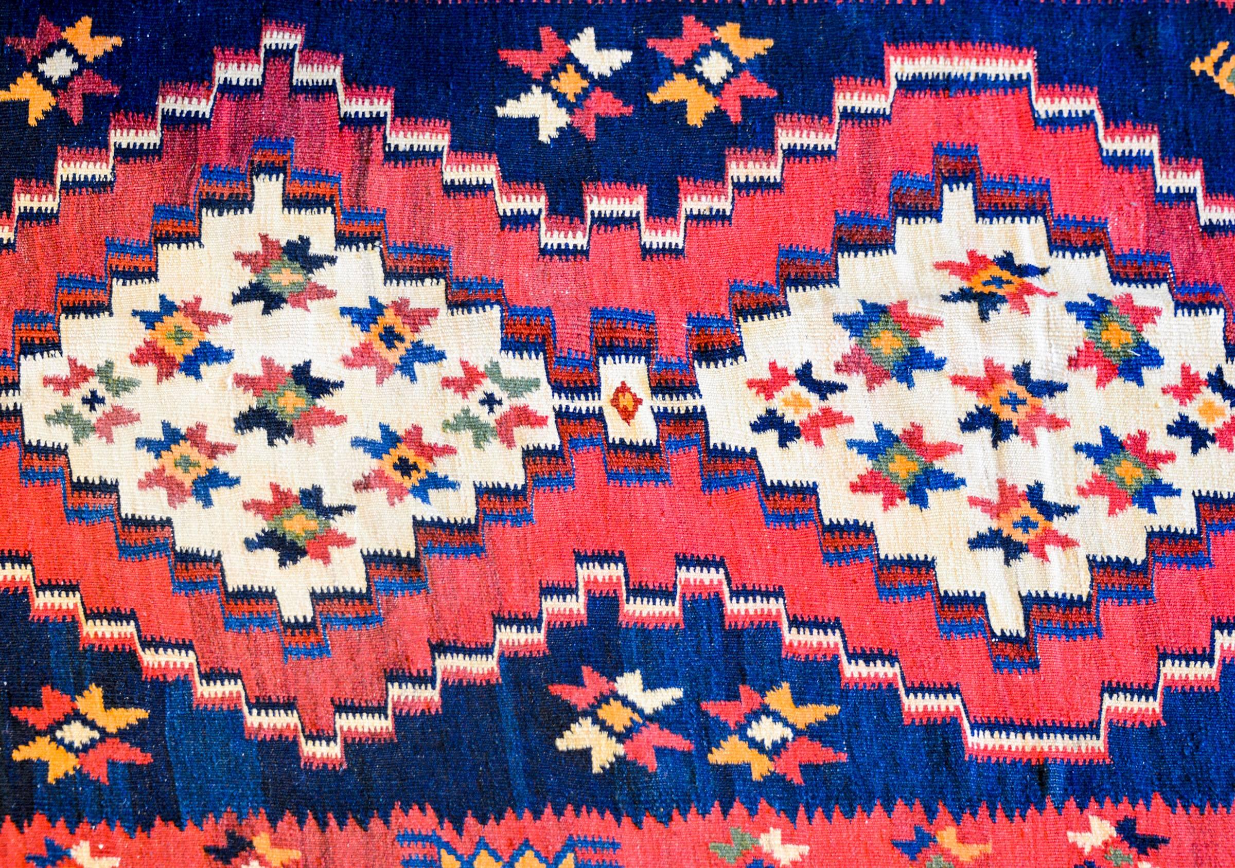 Exceptionnel tapis persan Rug & Kilim de la fin du 20e siècle. Il présente un motif brillant et magnifiquement tissé, composé de quatre grands médaillons en losange blanc, chacun orné de multiples fleurs stylisées multicolores, et d'une large