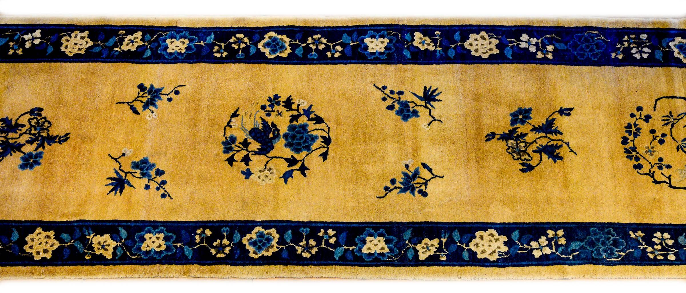 An exceptional early 20th century Chinese Art Deco runner with three floral medallions amidst a field of flowers woven in light and dark indigo on a natural undyed wool background. The borer is complementary with large auspicious flowers woven in