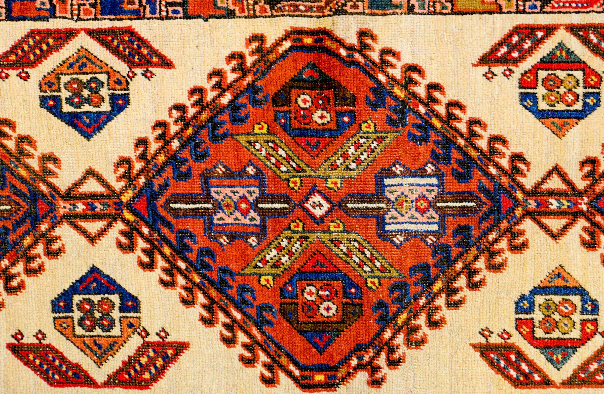 A rare and unusual early 1900s Persian Serab runner with three large-scale and boldly rendered diamond form medallions woven in crimson, gold, and indigo on a natural undyed camel hair background. The border is quite unique, almost cartoon-like,