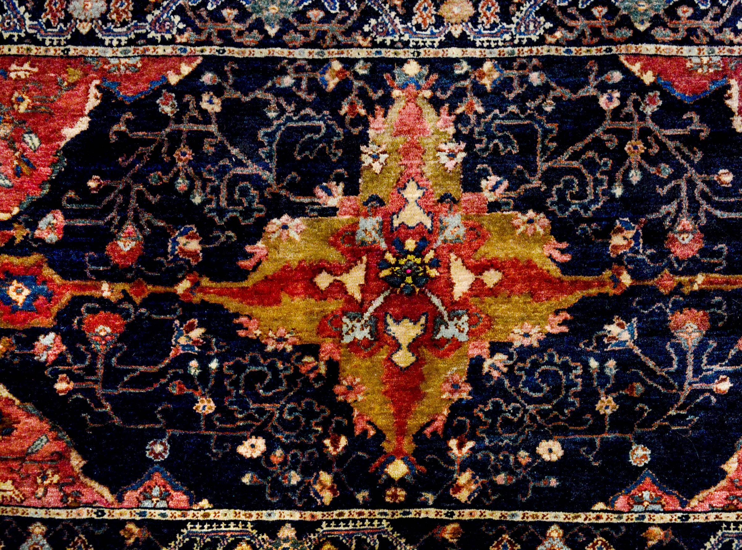 An incredible late 19th century Persian Mission Malayer rug with a wonderful slightly off-centre diamond medallion woven in crimson, salmon, pale indigo, and gold, amidst a field of black wool with very finely rendered scrolling vine and leaf