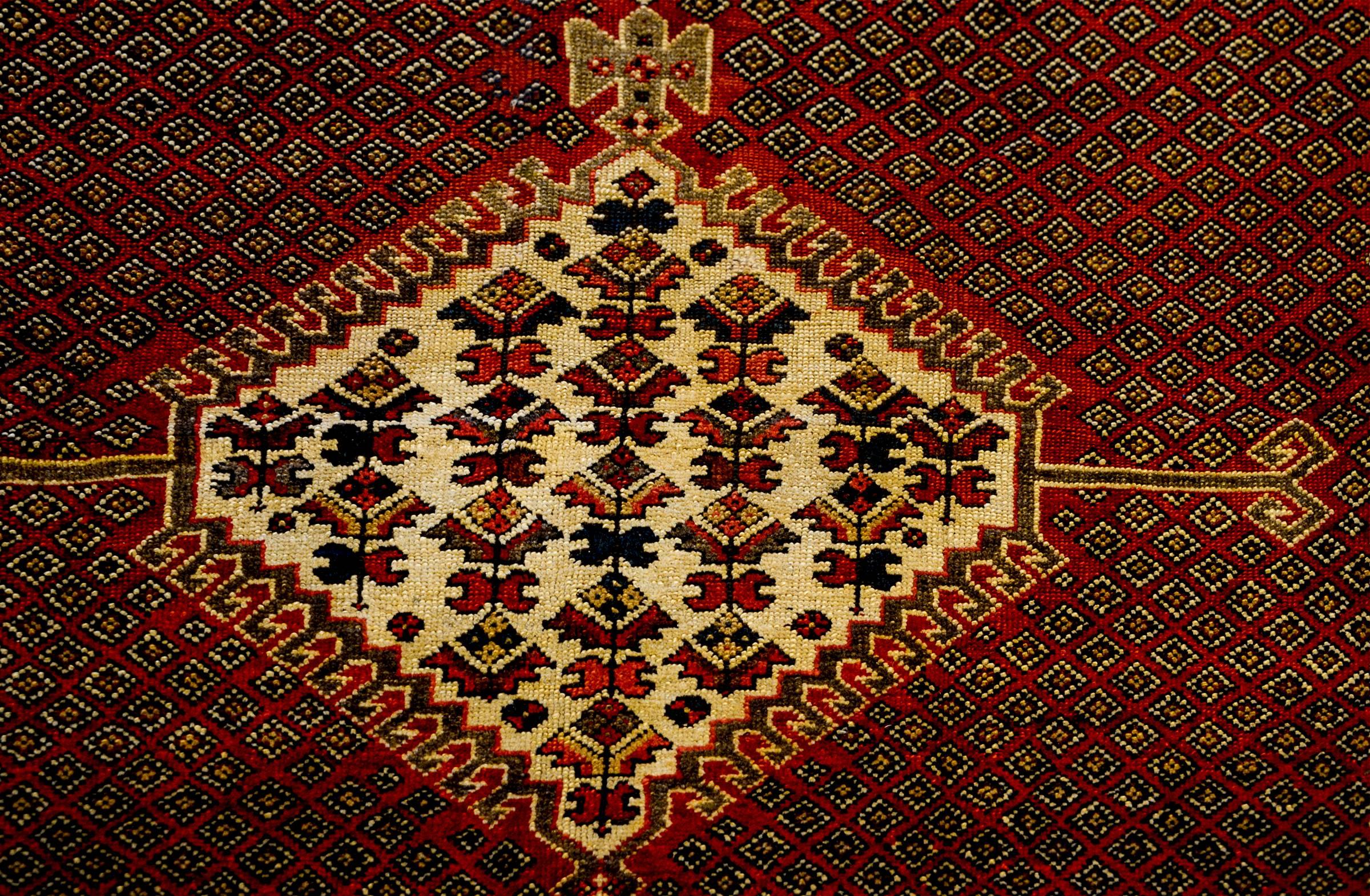 An amazing early 20th century Persian Ghashgaei rug with three large diamond medallions with a floral pattern, on a wonderful field of tightly woven diamonds on a brilliant crimson background. The border is fantastic with four distinct floral and