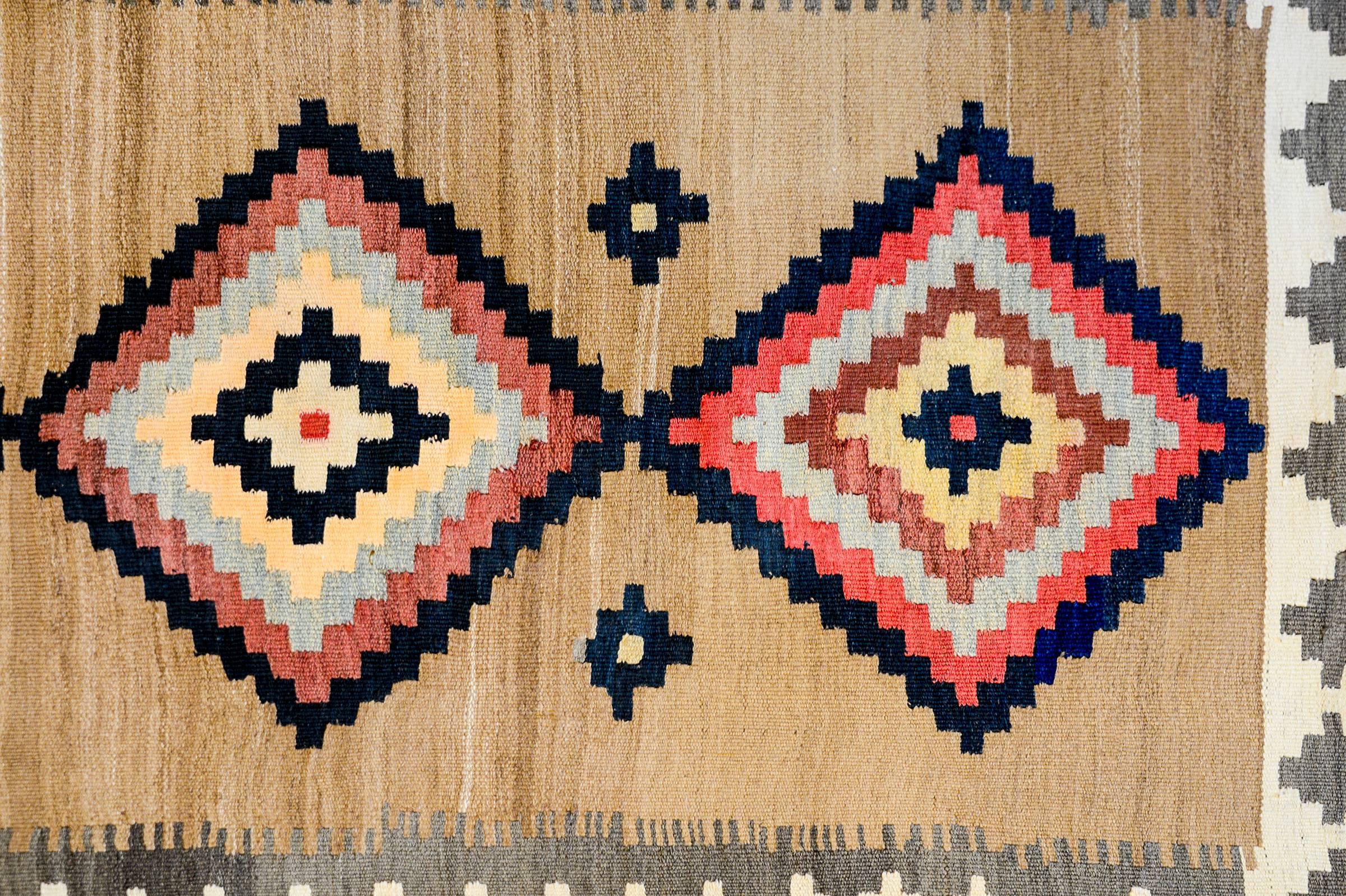 A wonderful early 20th century Persian Zarand Kilim runner with a fantastic pattern containing multiple diamond-form medallions with an incredible abrash natural wool background. The borer is wide with a geometric pattern.