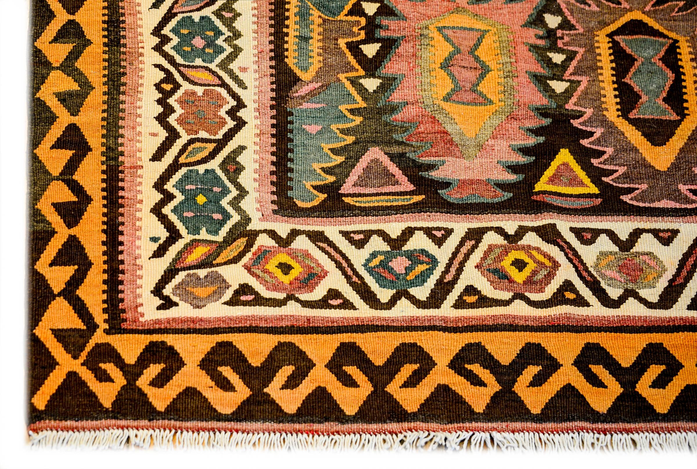A beautiful early 20th century Persian Qazvin Kilim rug with a rare all-over orange, purple, black, crimson, pink and white tree-of-life pattern surrounded by multiple geometric patterned borders. The inner border is white with multicolored stylized