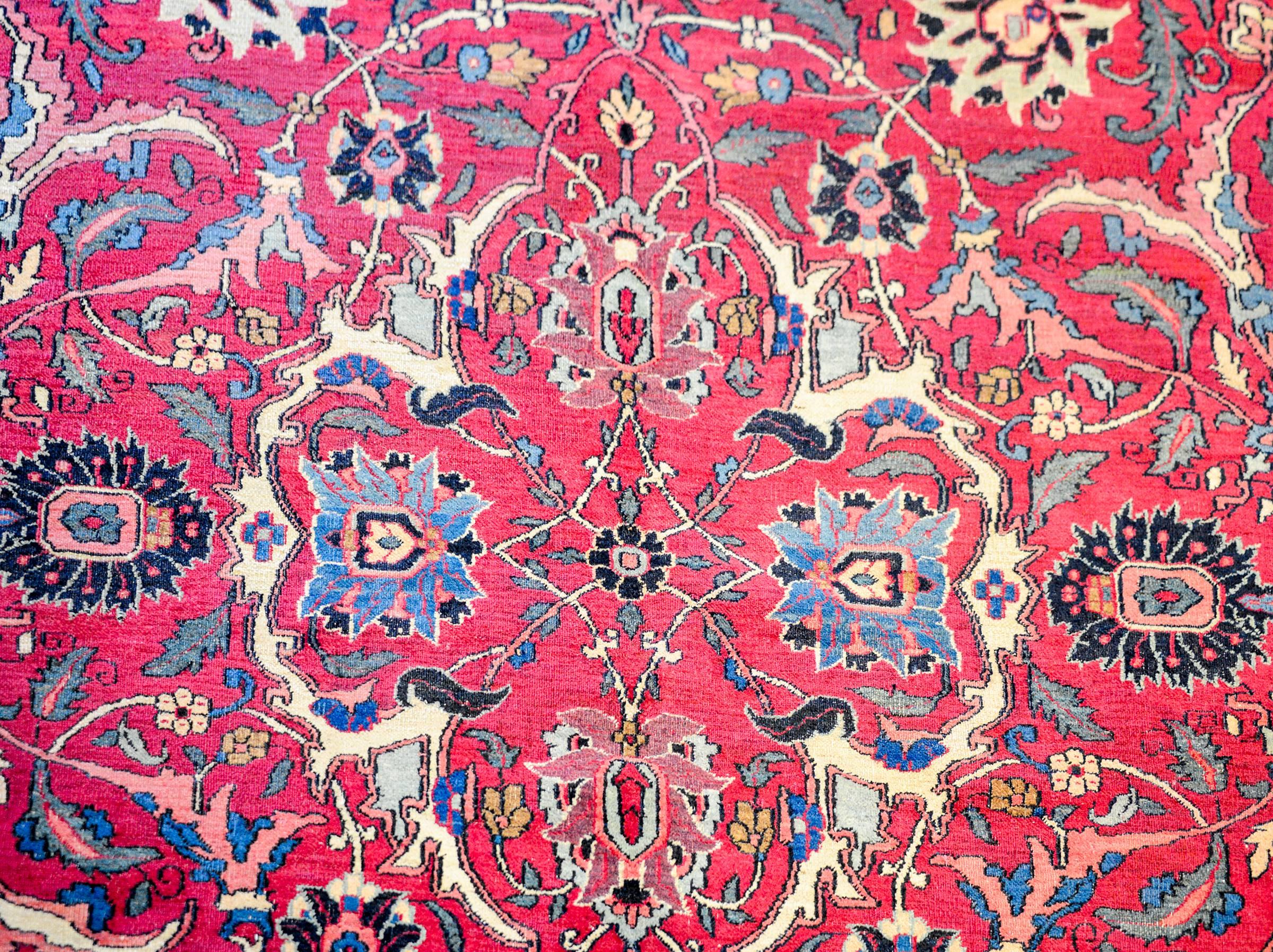 A magnificent early 20th century Persian Dorokhsh rug with a fantastic large-scale floral and vine lattice pattern, expertly rendered, in light and dark indigo, pink, gold, and natural undyed wool, on a bold fuschia background. The border is wide,