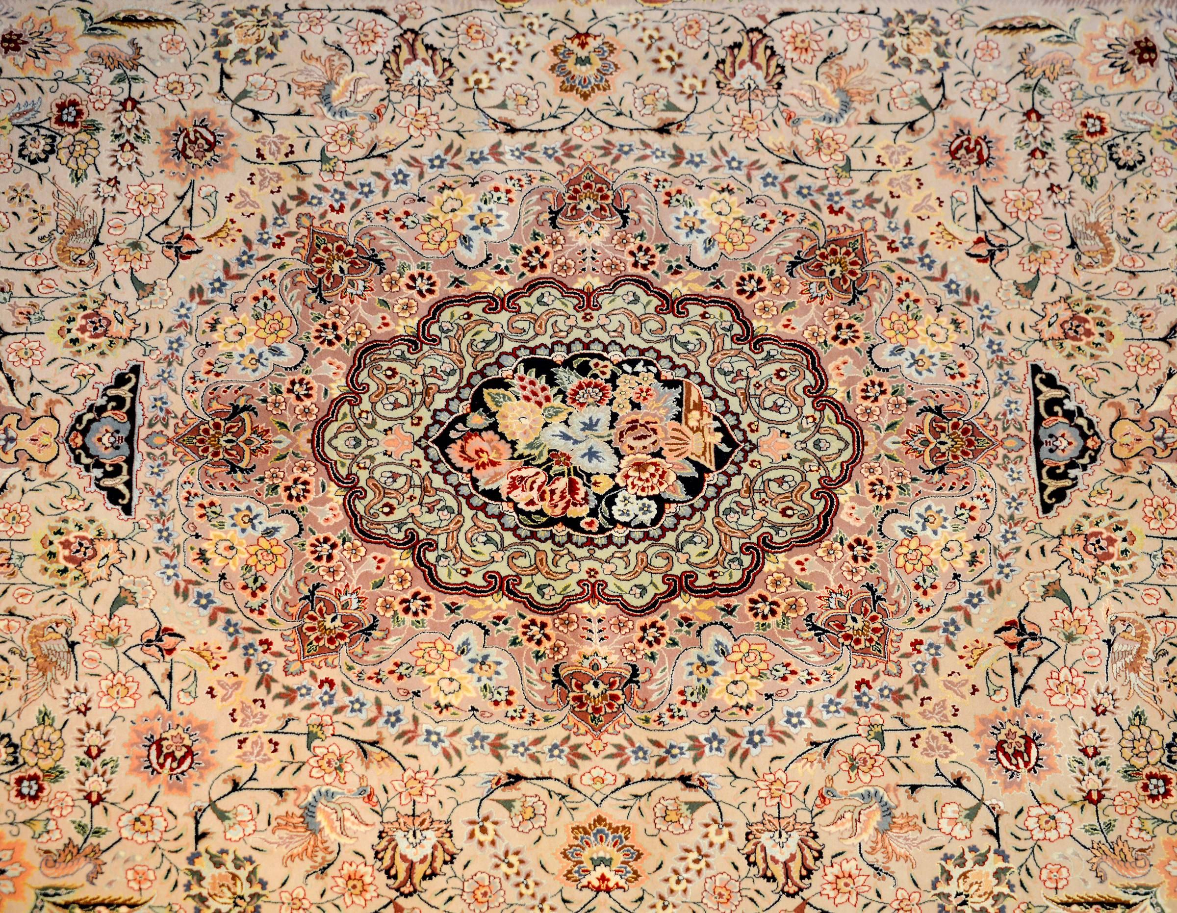 A wonderful vintage, Persian Tabriz rug with a mesmerizing pattern of intricately and tightly woven pattern of multicolored flowers and scrolling vines woven in vegetable dyed silk and wool. The border is complex with a large central field of
