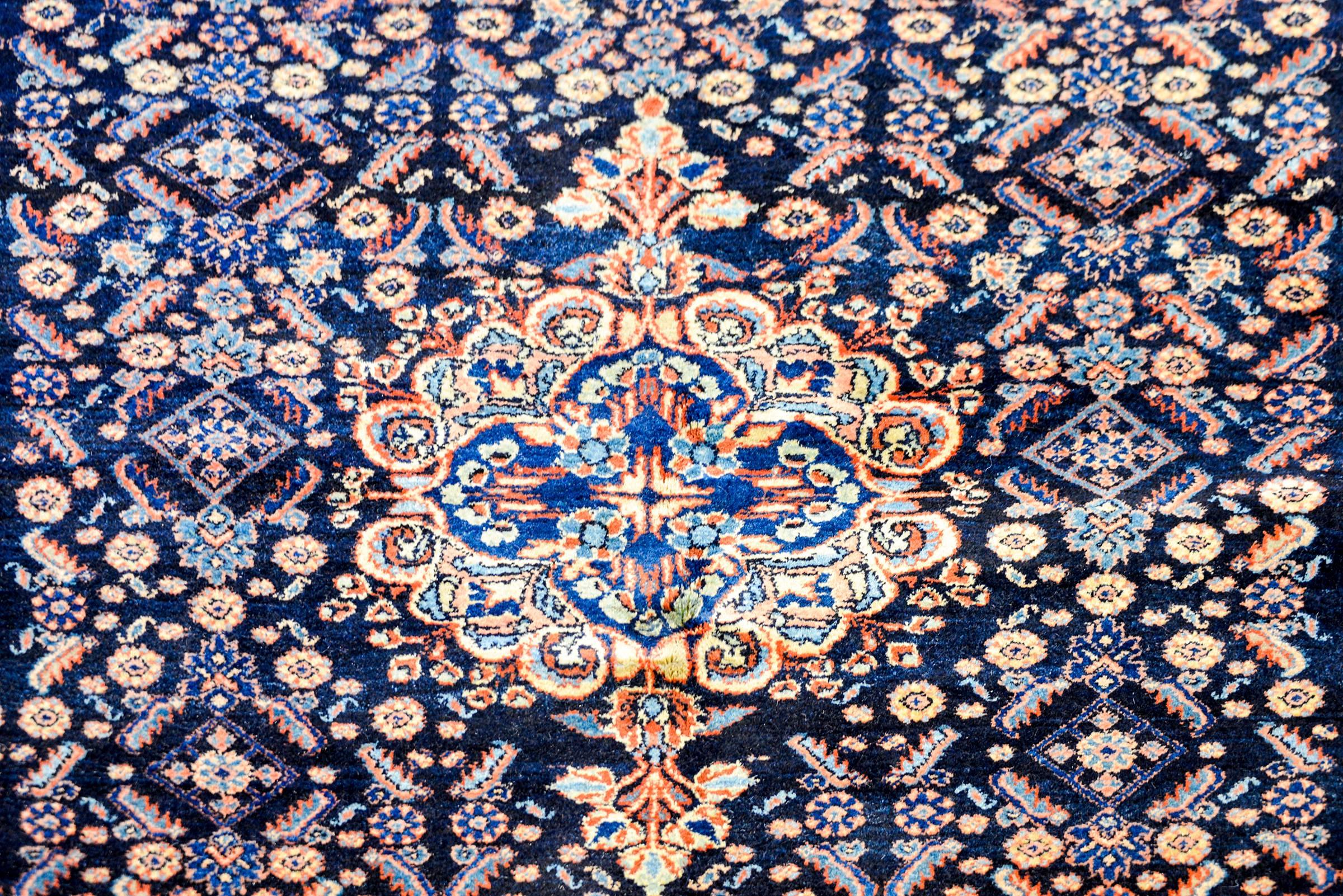 Ein wunderbarer persischer Sarouk-Moharramat-Teppich aus dem frühen 20. Jahrhundert mit einem kühnen, floralen Gittermuster in Karminrot, Rosa, hellem Indigo und Gold auf einem satten, dunkel indigoblauen Hintergrund. Die Bordüre ist kontrastierend