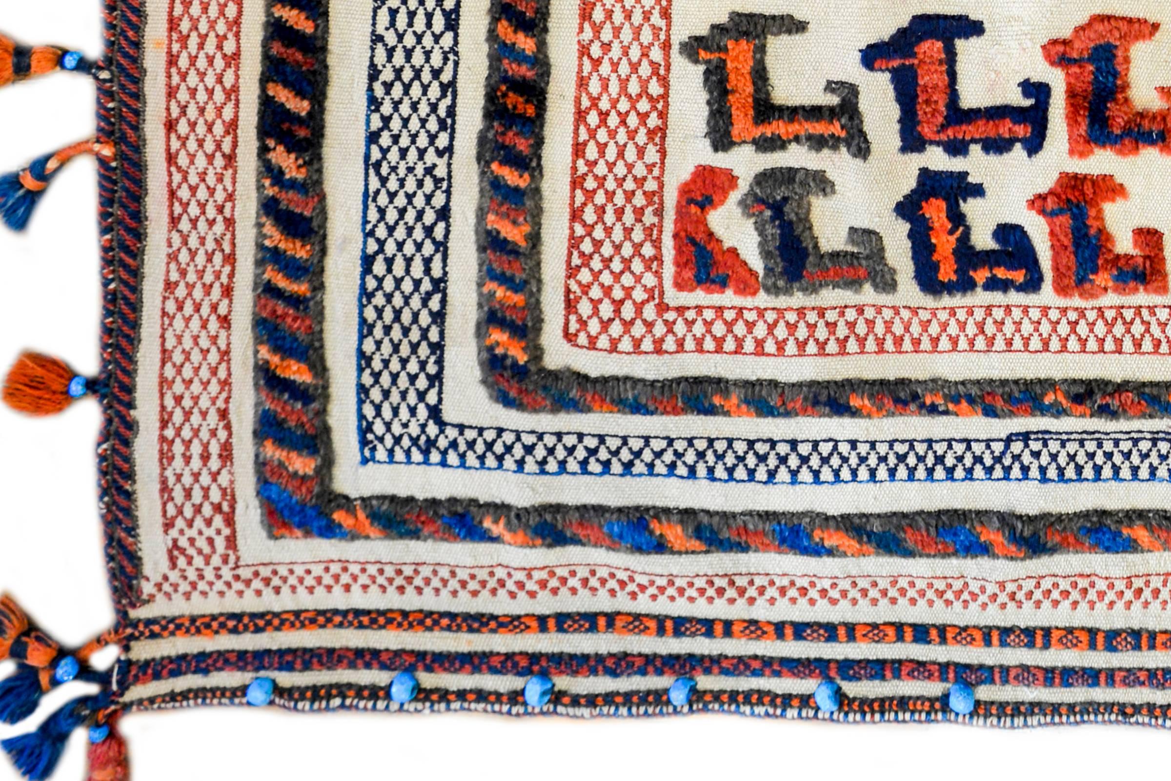 An amazing 20th century Persian Afshar horse blanket with a beautiful whimsical pattern of multicolored goats woven surrounded by a border of multiple pile and embroidered stripes, with tassels all around.