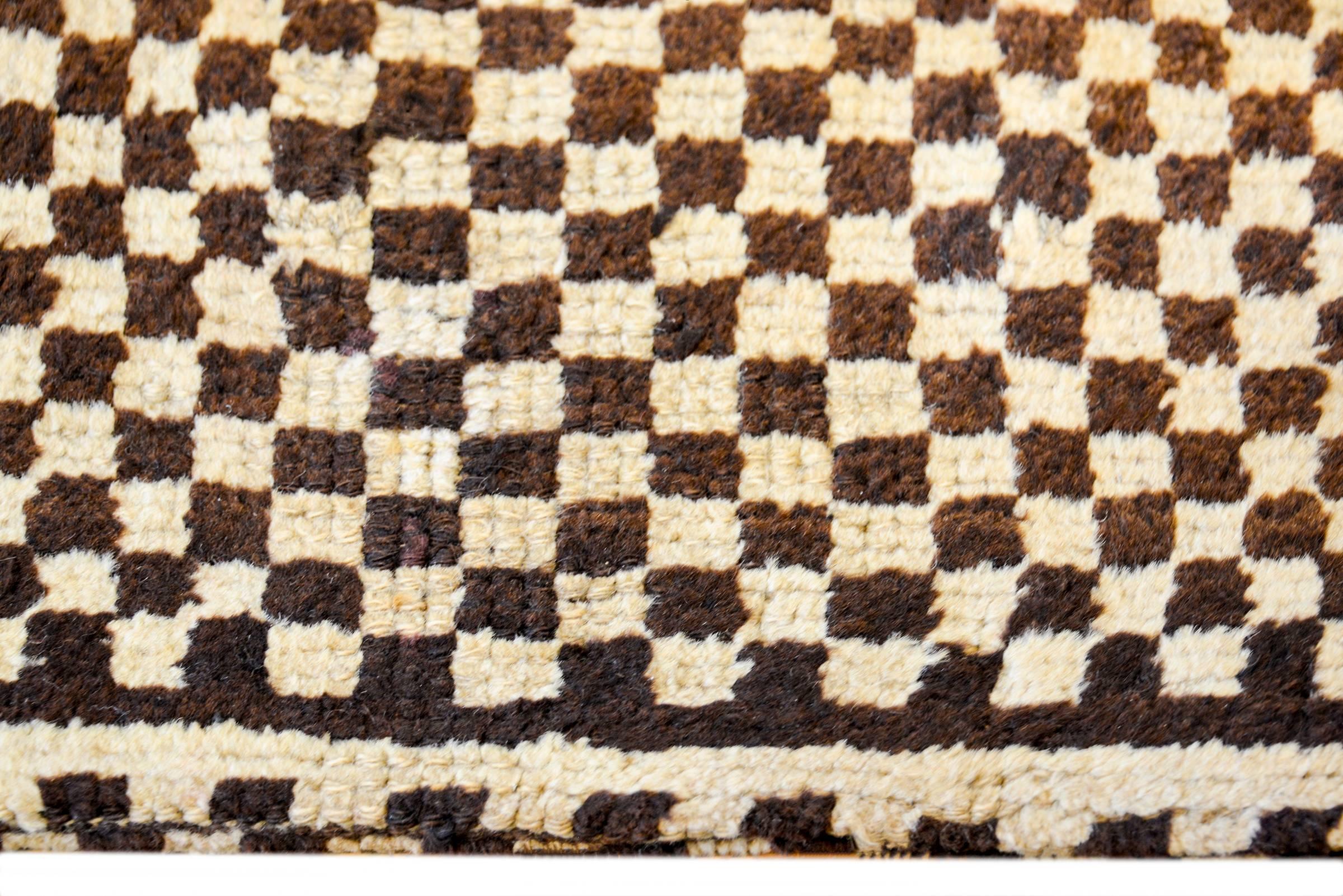 A fantastic and boldly woven early 20th century Persian Gabbeh grain bag with a beautiful woven checkerboard pattern on a stripped ground, woven in natural undyed wool.