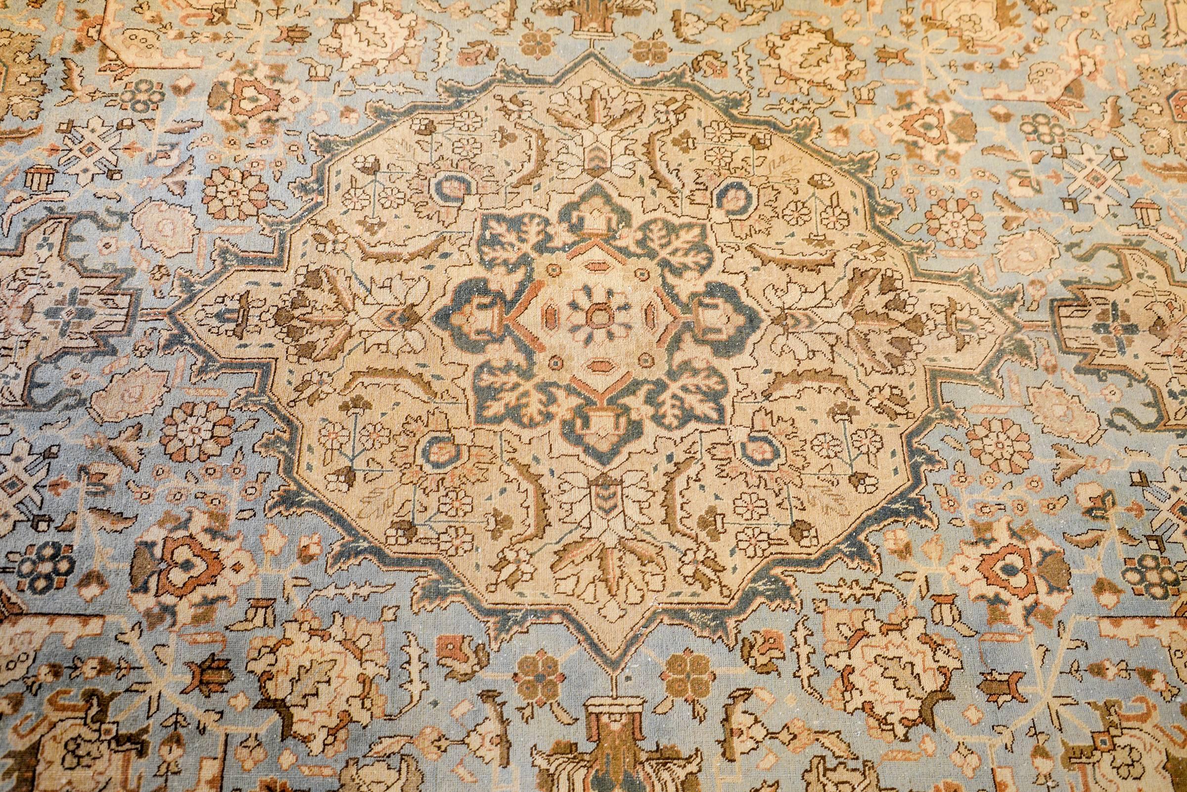 A wonderful mid-20th century Persian Tabriz rug with a fantastic pattern of intricately and tightly woven pattern containing a large central medallion amidst a field of multicolored flowers and scrolling vines woven in vegetable dyed wool. The