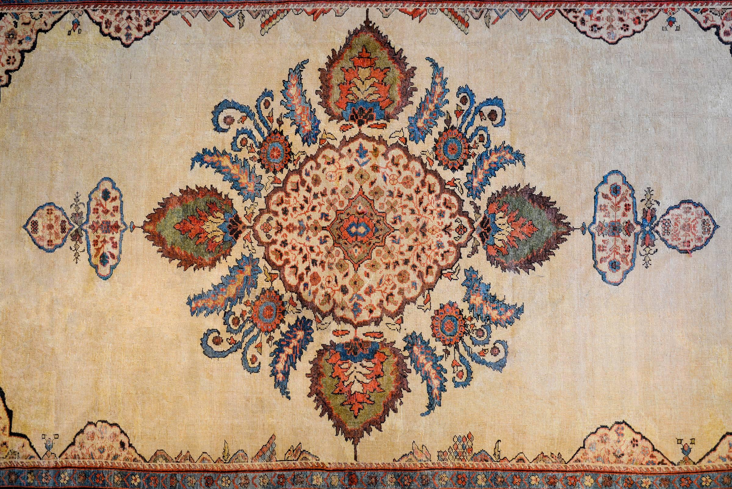 An unbelievable mid-19th century Persian Ziegler Sultanabad rug with a beautiful large-scale floral and leaf medallion woven in indigo, crimson, green, gold, and natural brown wool on a fantastic undyed natural cream colored wool background. The