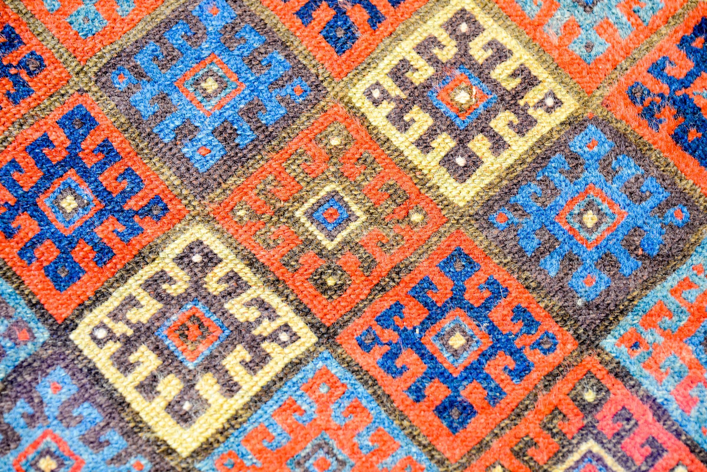 An exceptional late 19th century Persian Kurdish bag face rug with a wonderful pattern containing multiple diamonds with geometric forms woven in crimson, light and dark indigo, and yellow colored wool. The border is complex, with two wide stripes,