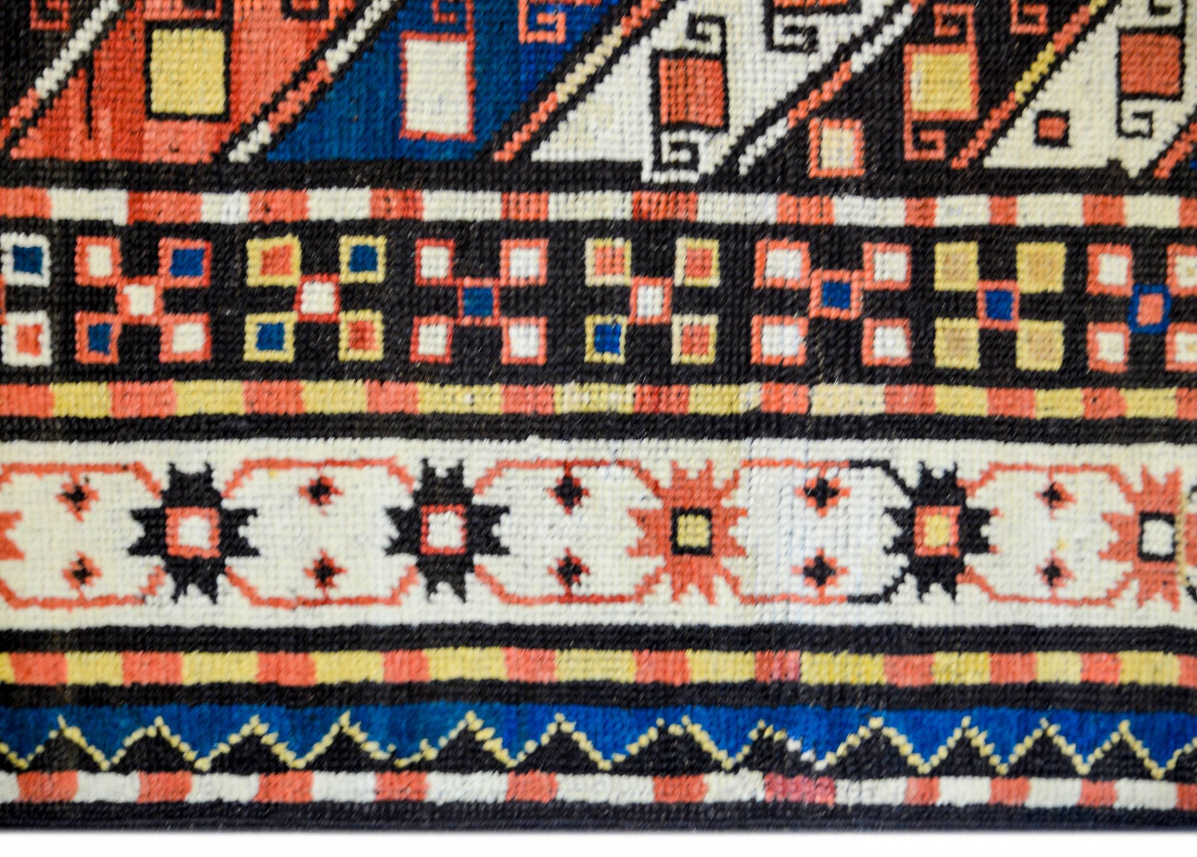 Fantastique tapis persan Kazak de la fin du XIXe siècle, présentant un magnifique motif de bandes diagonales multicolores à motifs géométriques, entourées d'une large bordure composée de multiples bandes à motifs géométriques et floraux stylisés, le