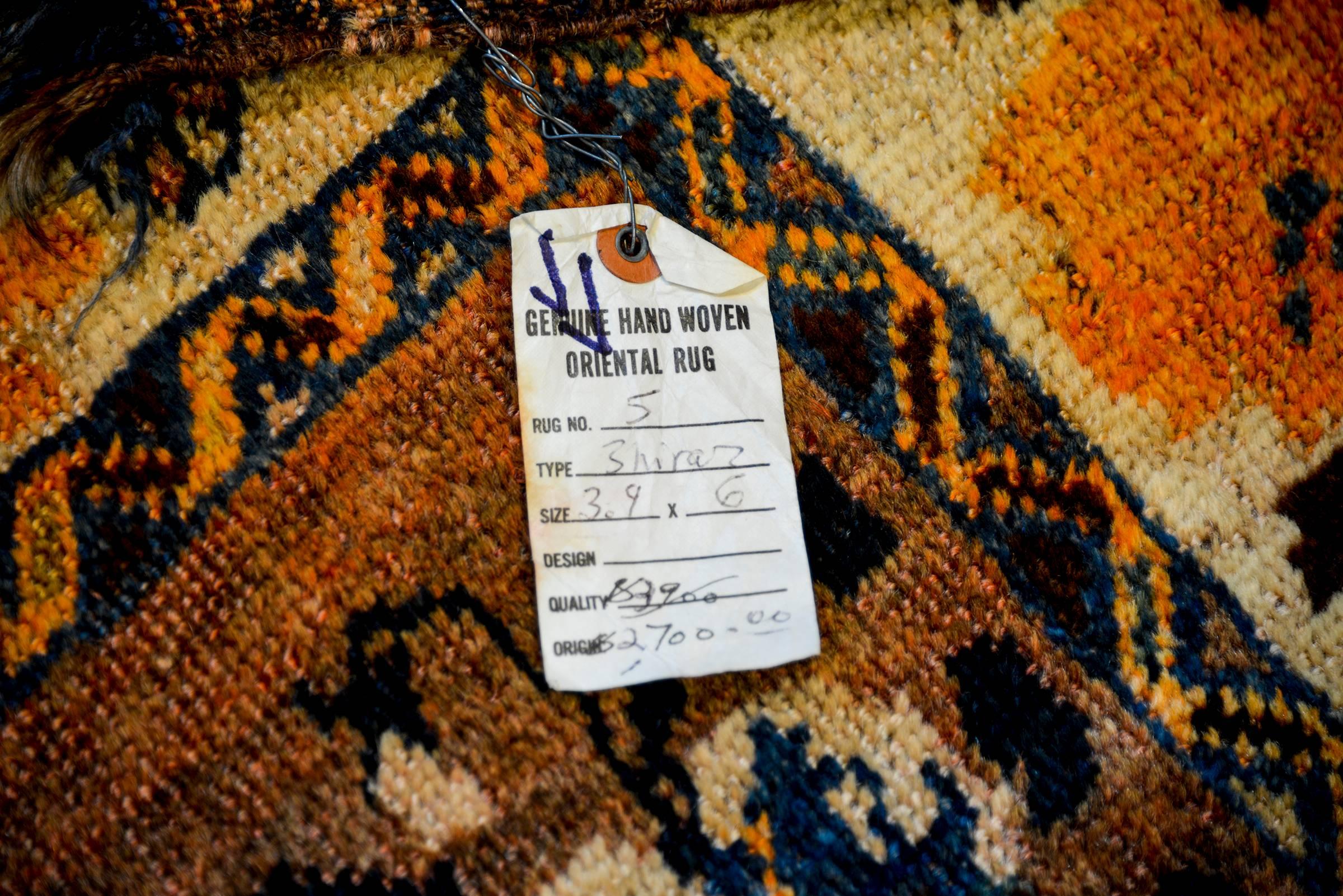 A unique late 20th century Shiraz rug with a beautiful all-over light and dark indigo, gold and brown floral pattern on an abrash crimson background that fades from light to dark across the field. The border is fantastic with a wide large-scale