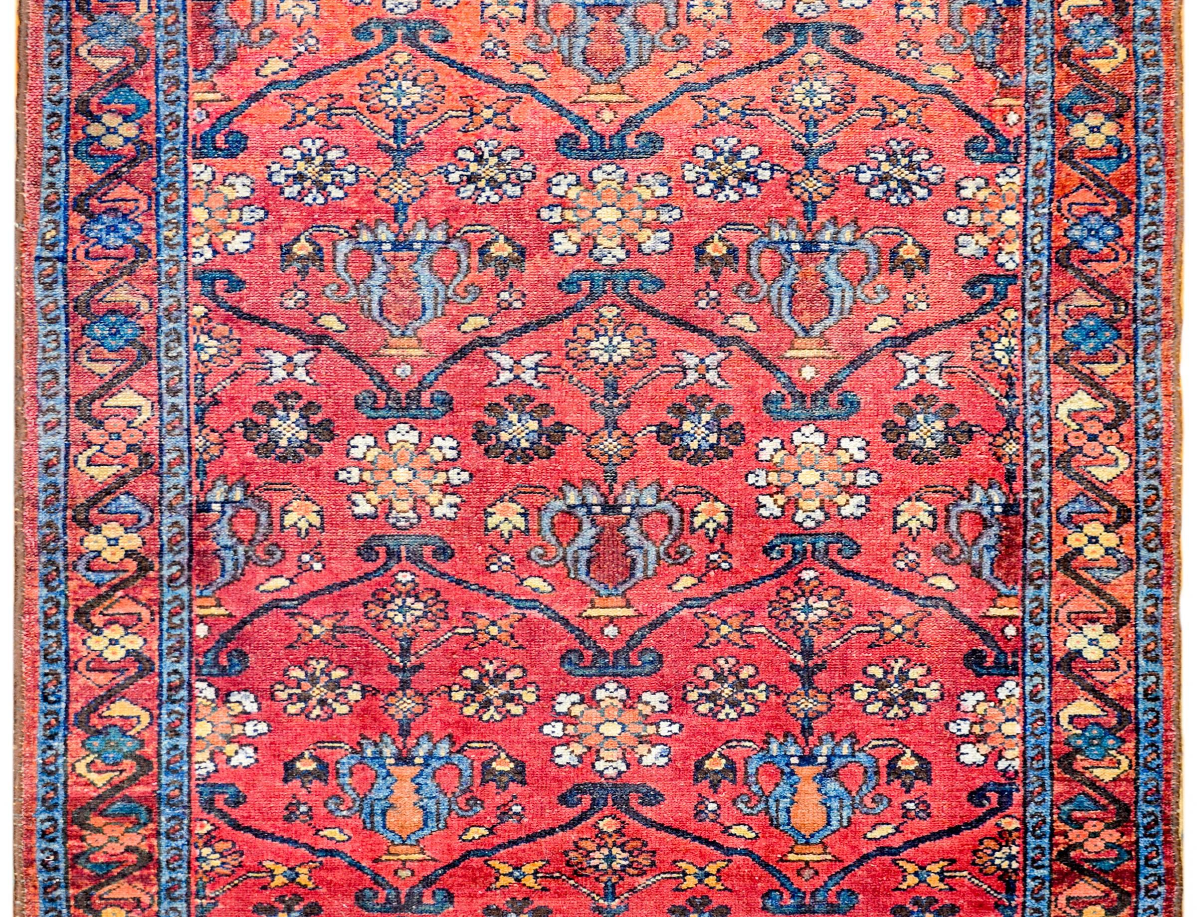 An amazing early 20th century Persian Lilihan rug with a bright crimson background, covered by a lacy, multicolored scrolling vine and floral pattern, surrounded by a wide complementary border with a large-scale floral pattern.