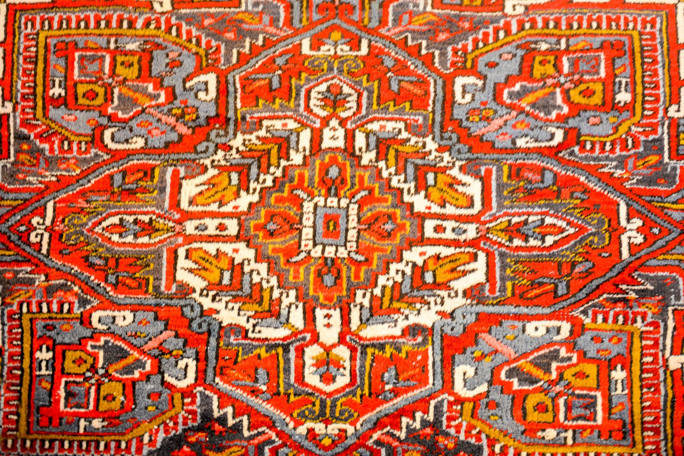 An amazing mid-20th century Persian Heriz rug with a large central multi-lobed floral medallion on a rich crimson background. The field is intensely woven with a complementary floral pattern. The border is comprised of a wide stylized floral pattern