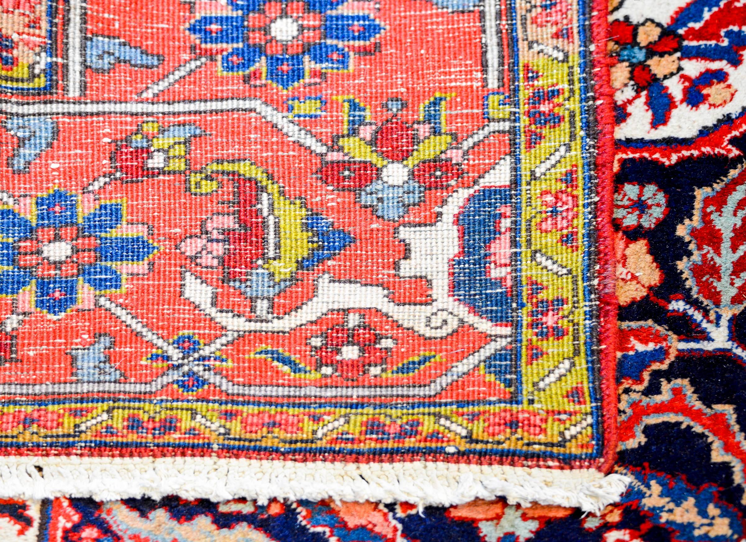 Ein erstaunlicher persischer Heriz-Teppich aus der Mitte des 20. Jahrhunderts mit einem großen zentralen mehrlappigen Blumenmedaillon auf schwarzem Hintergrund. Das Feld ist mit einem komplementären floralen Muster intensiv gewebt. Die Bordüre