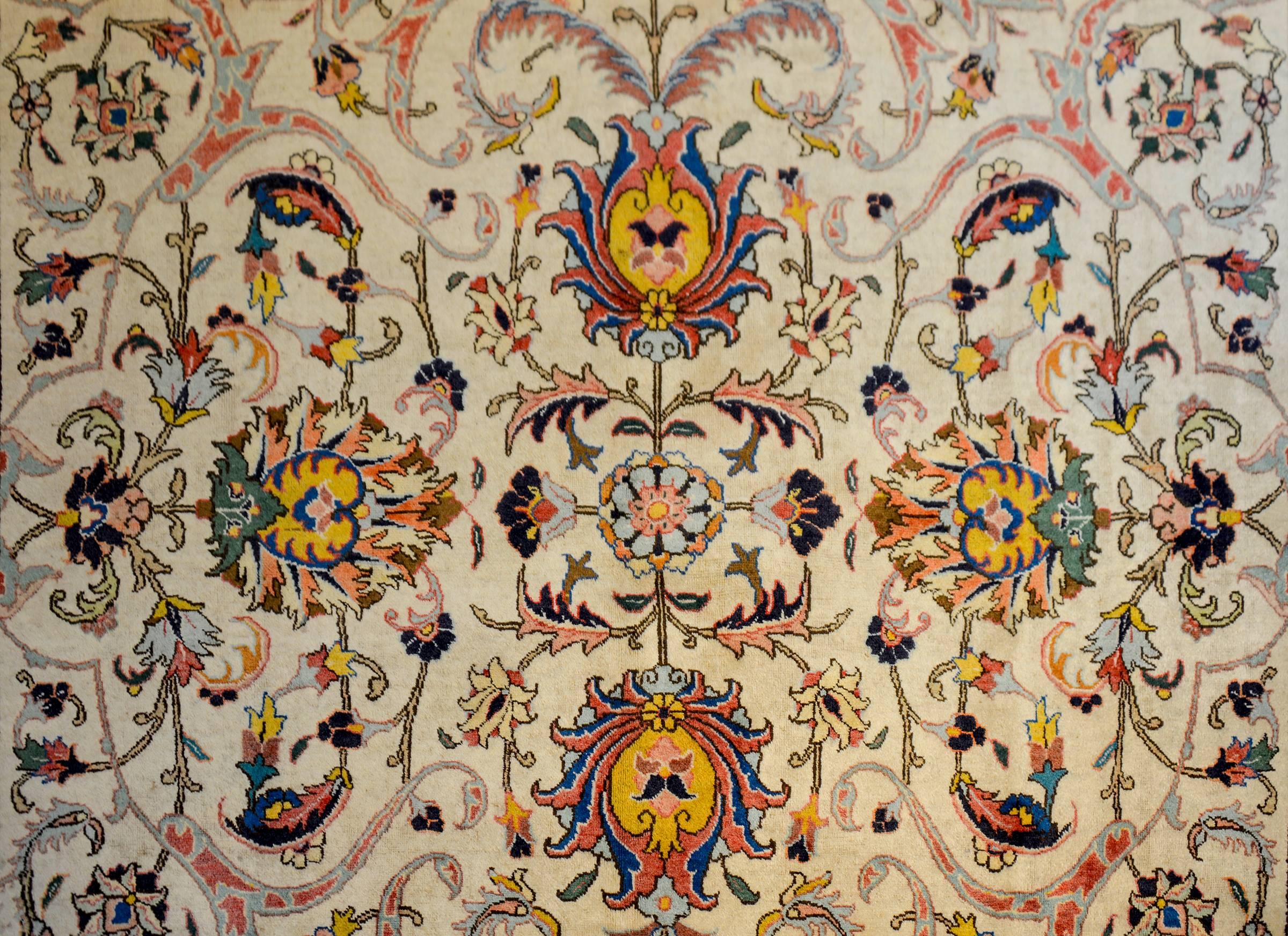 Ein außergewöhnlicher persischer Täbriz-Teppich aus dem frühen 20. Jahrhundert mit einem unglaublichen mehrfarbigen, gespiegelten Blumen- und Rankenmuster auf einem natürlichen, ungefärbten Wollgrund. Die Grenze ist erstaunlich, mit einem breiten