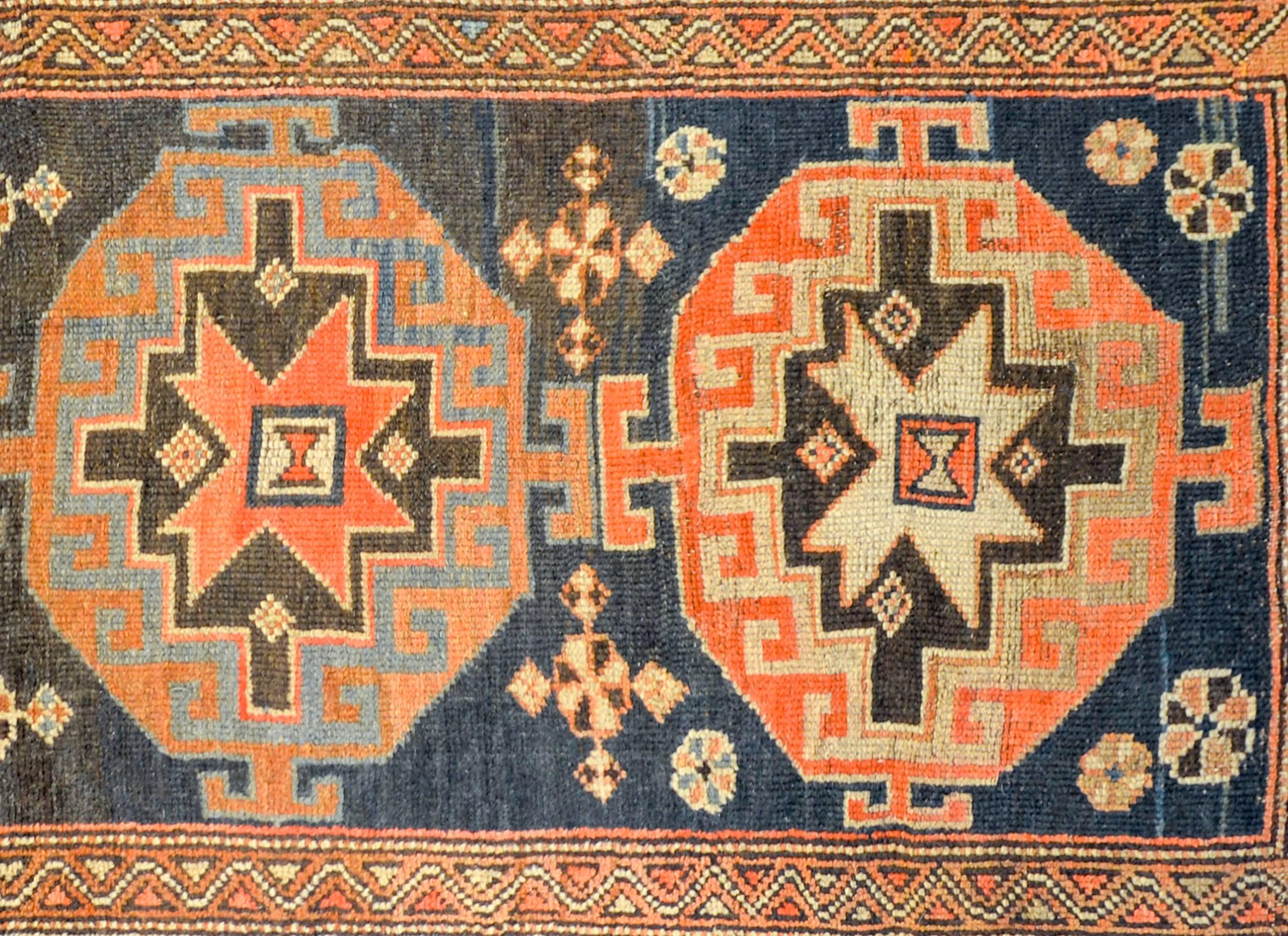 A beautiful early 20th century Persian Karebak rug with four large octagonal medallions, each woven in alternating colors of crimson, indigo, brown, and natural wool, on a wonderful deep indigo field of stylized flowers. The border is complex, with