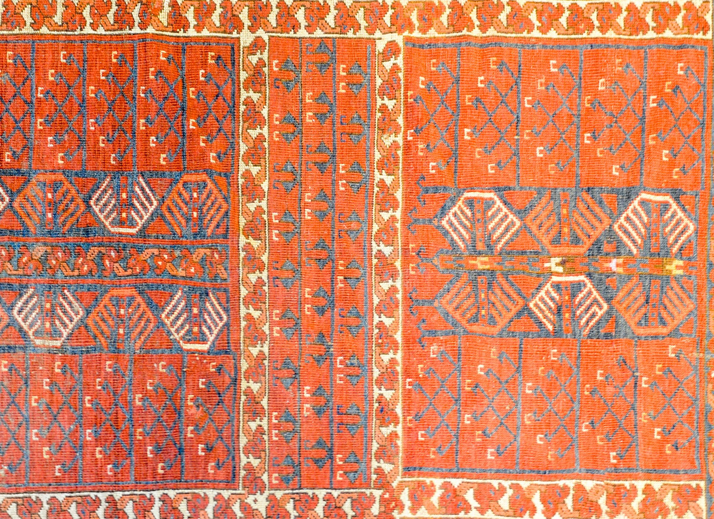 An exceptional early 20th century Afghani Ersari rug with an incredible pattern with stylized trees-of-life on a brilliant crimson background. Surrounding the trees-of-life are stylized floral motif bands on a natural undyed wool background. The