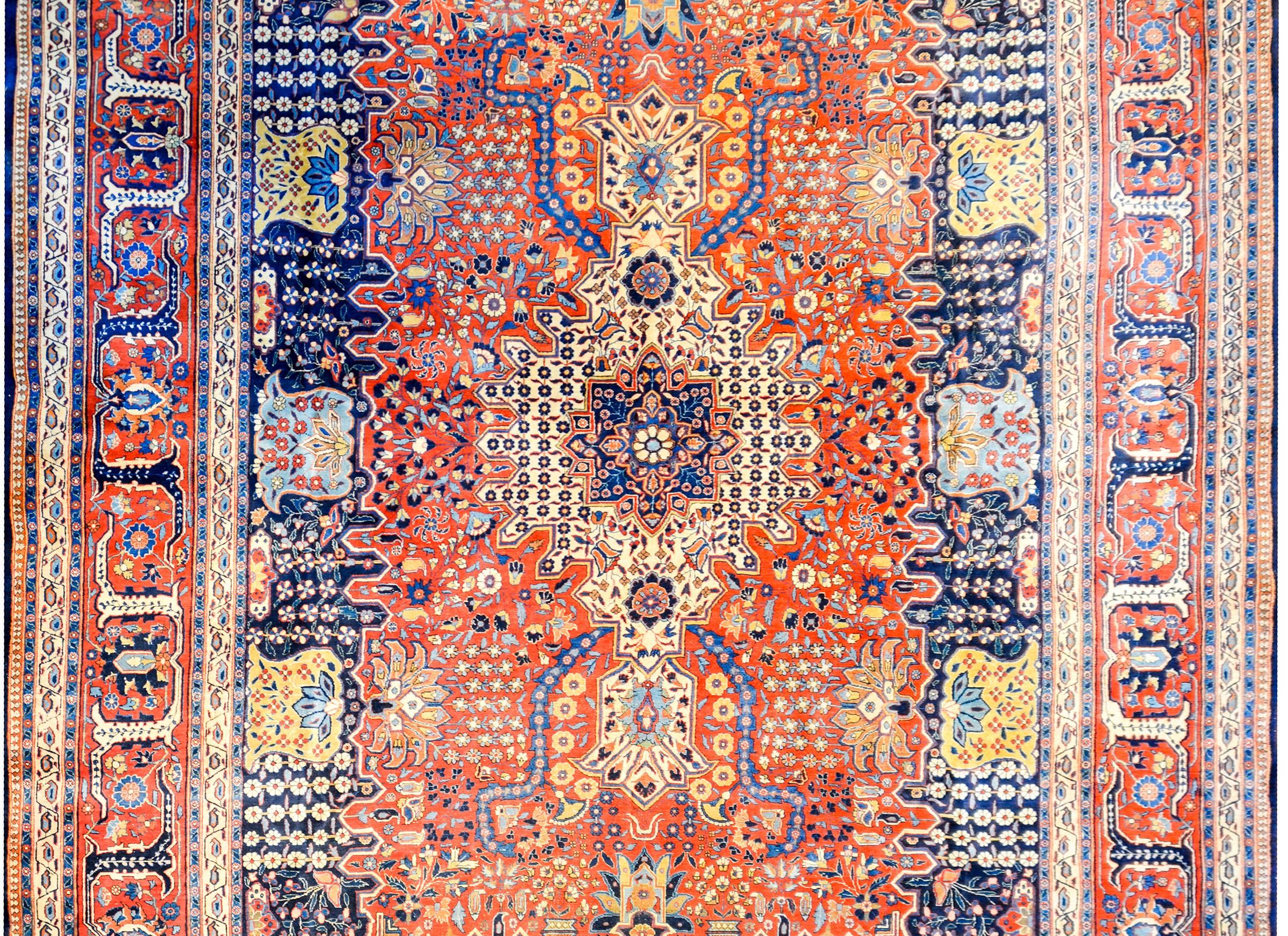 An unbelievable early 20th century Persian Dabir Kashan rug with the most densely woven field we've ever seen containing myriad flowers, leaves, and vines, all woven in crimson, indigo, gold, and cream colored vegetable dyed wool. The border is as