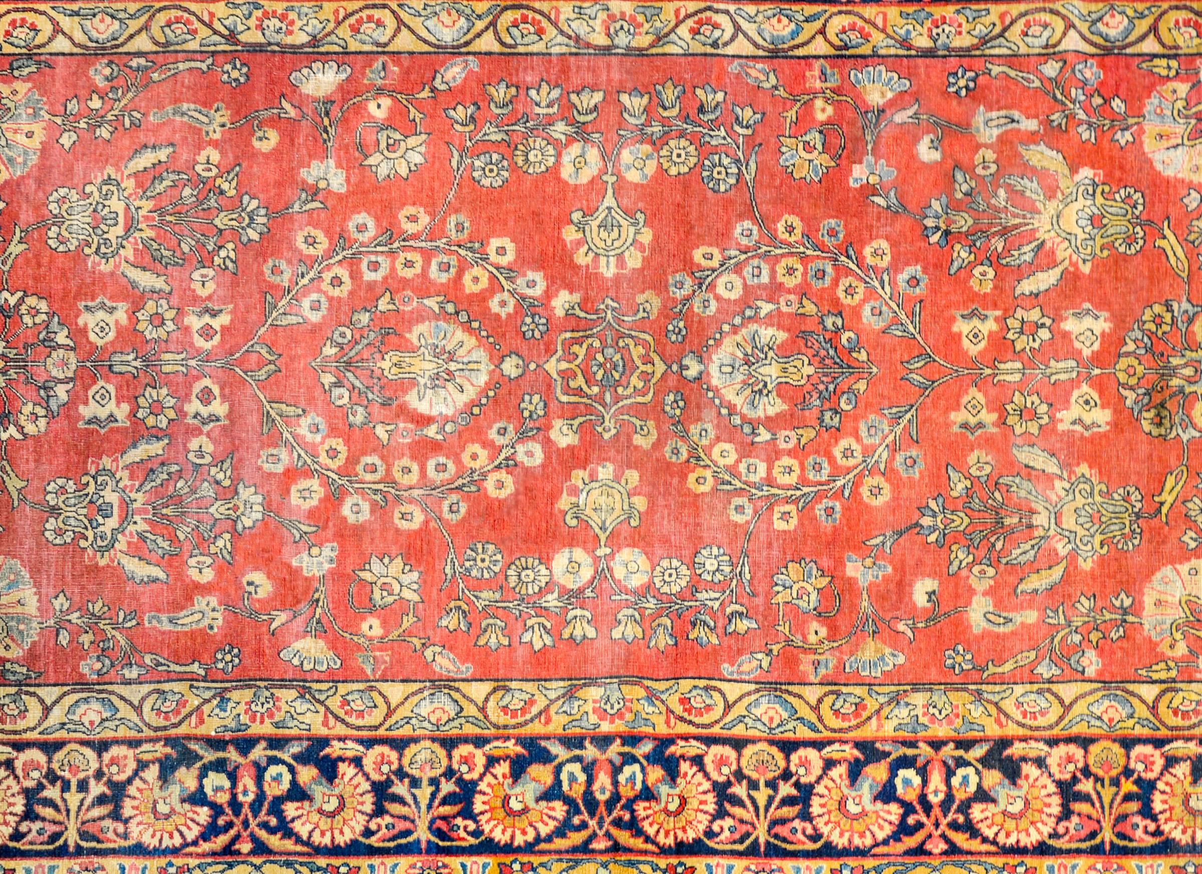 Ein wunderschöner persischer Kirman-Teppich aus dem frühen 20. Jahrhundert mit einem fantastischen, gespiegelten Blumen- und Rankenmuster, das fachmännisch in hellem und dunklem Indigo, Gold und natürlicher, ungefärbter Wolle auf einem karminroten