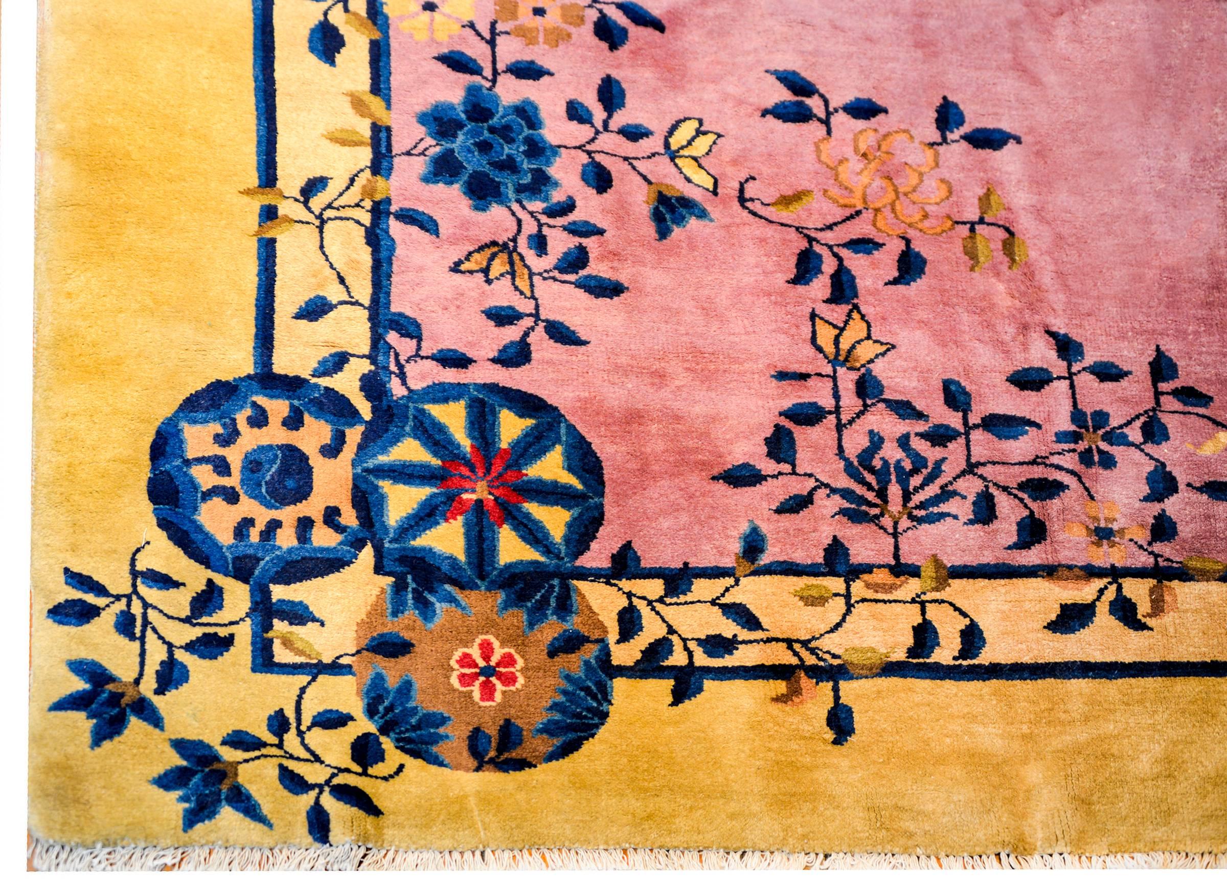 A gorgeous early 20th century Chinese Art Deco rug with a beautiful rose colored field surrounded by a soft champagne colored border. Multicolored potted peonies, lotus, and cherry blossoms and leafy branches are overlaid in several locations, with