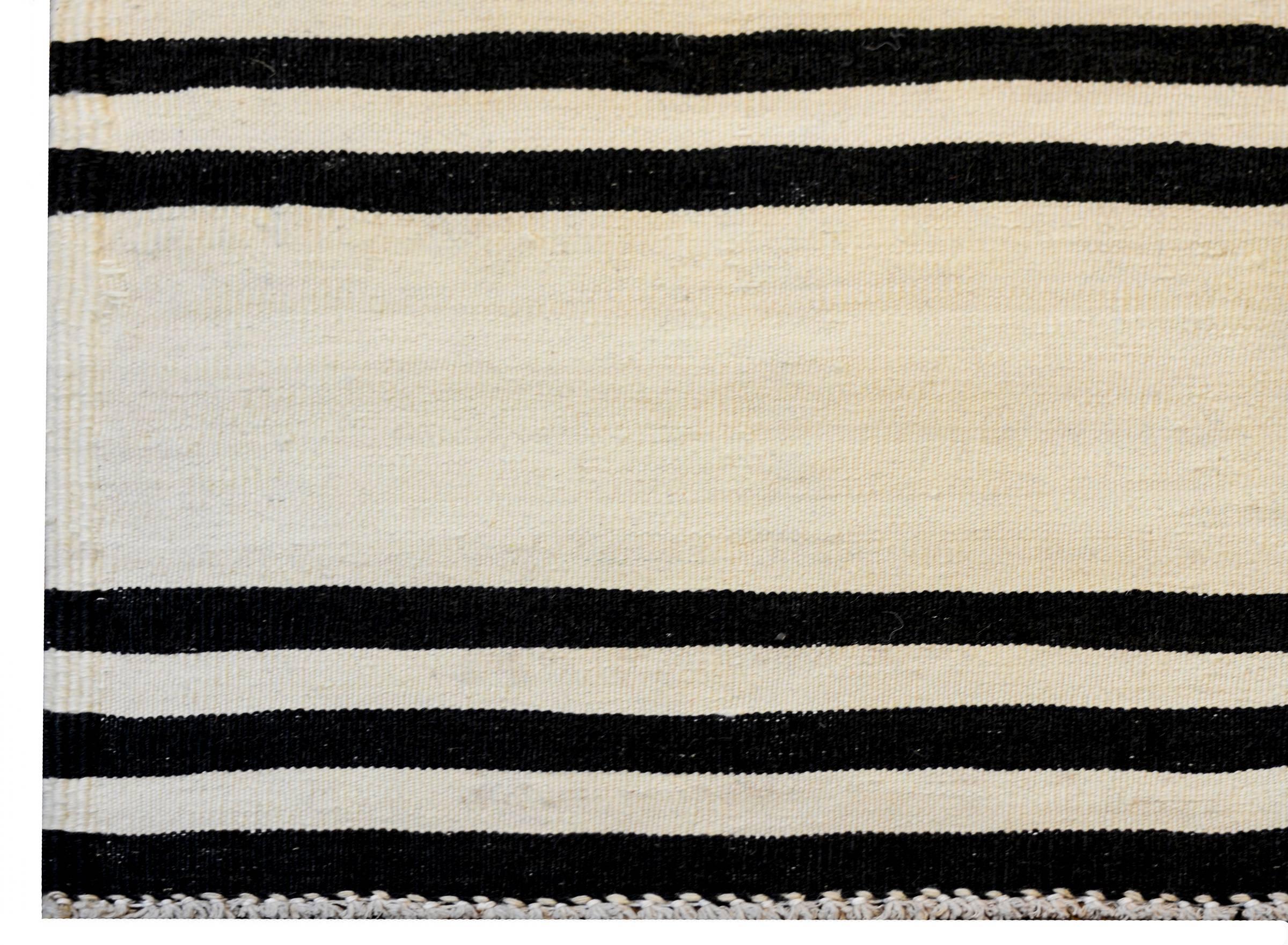 A wonderful early mid-20th century Persian Gabbeh Kilim runner with a bold horizontal stripe pattern with alternating black and natural wool stripes.