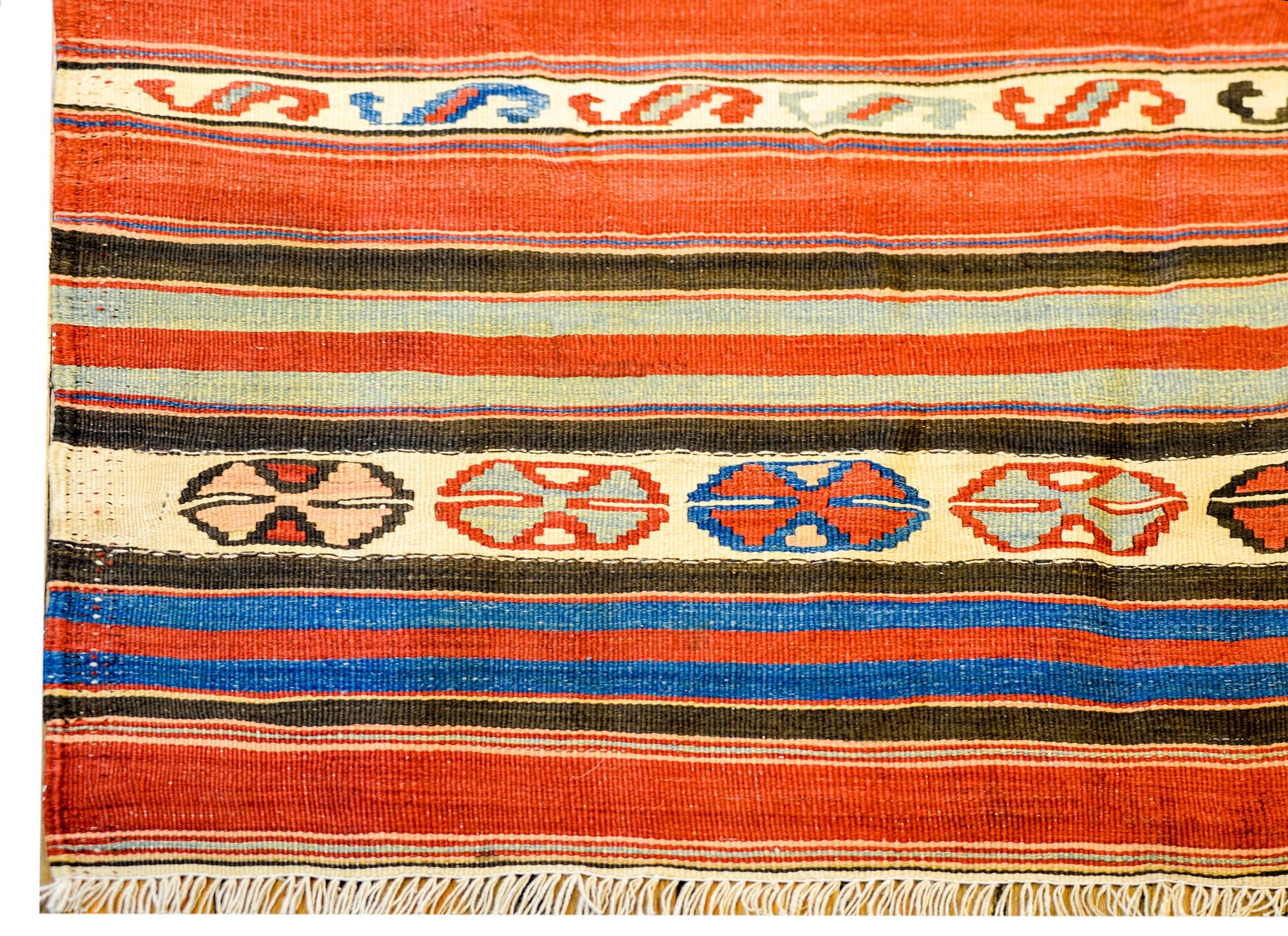 A wonderful early 20th century Persian Zarand Kilim runner with alternating boldly colored multicolored stripes of geometric and striped design. The border is thin, with a diamond and zigzag pattern.