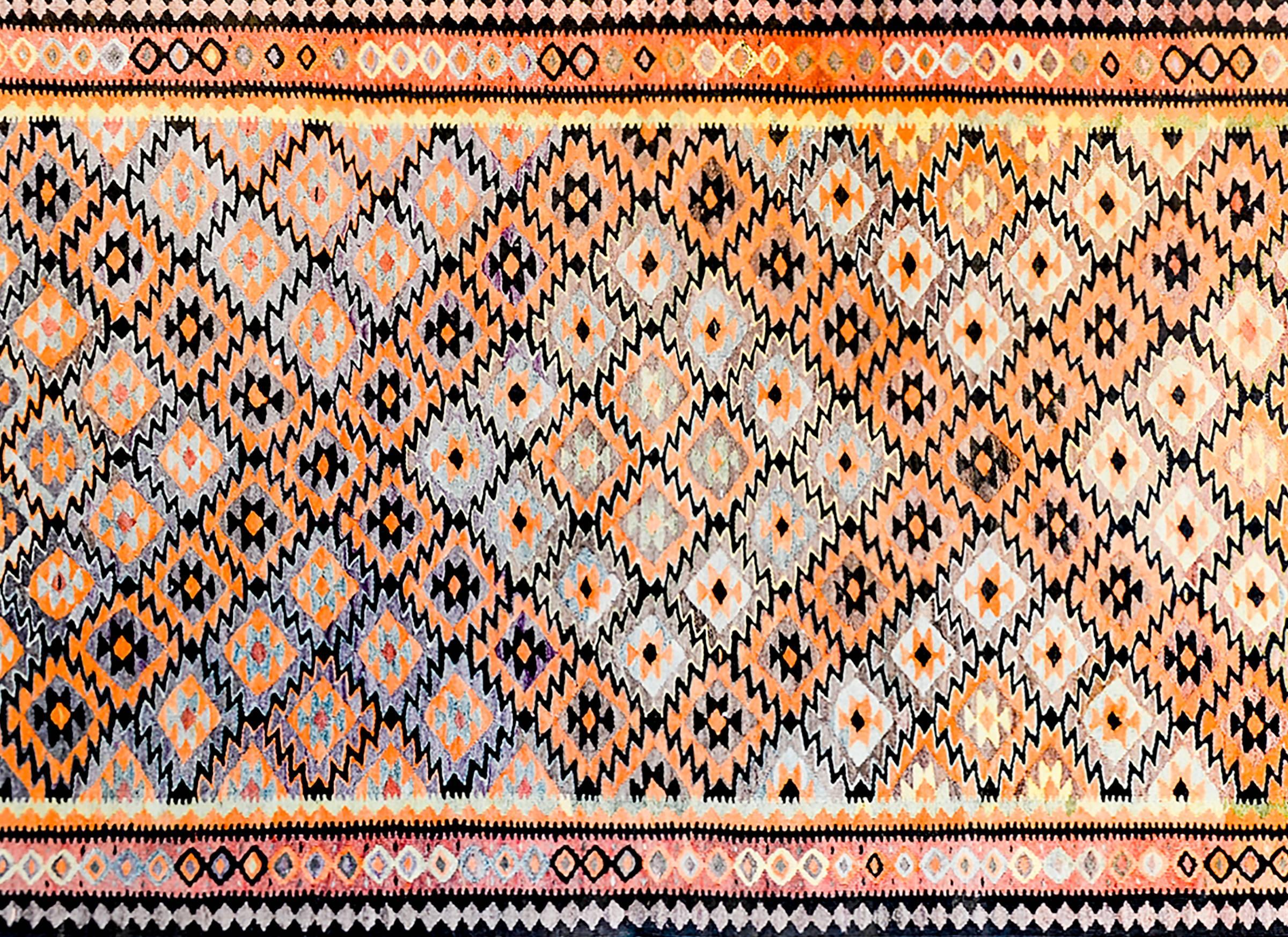 An amazing mid-20th century Persian Qazvin Kilim rug with an multi-colored diamond pattern woven in such a way that a larger diamond pattern of orange, lilac, back and natural wool colored diamonds is created. The border is complex, with three