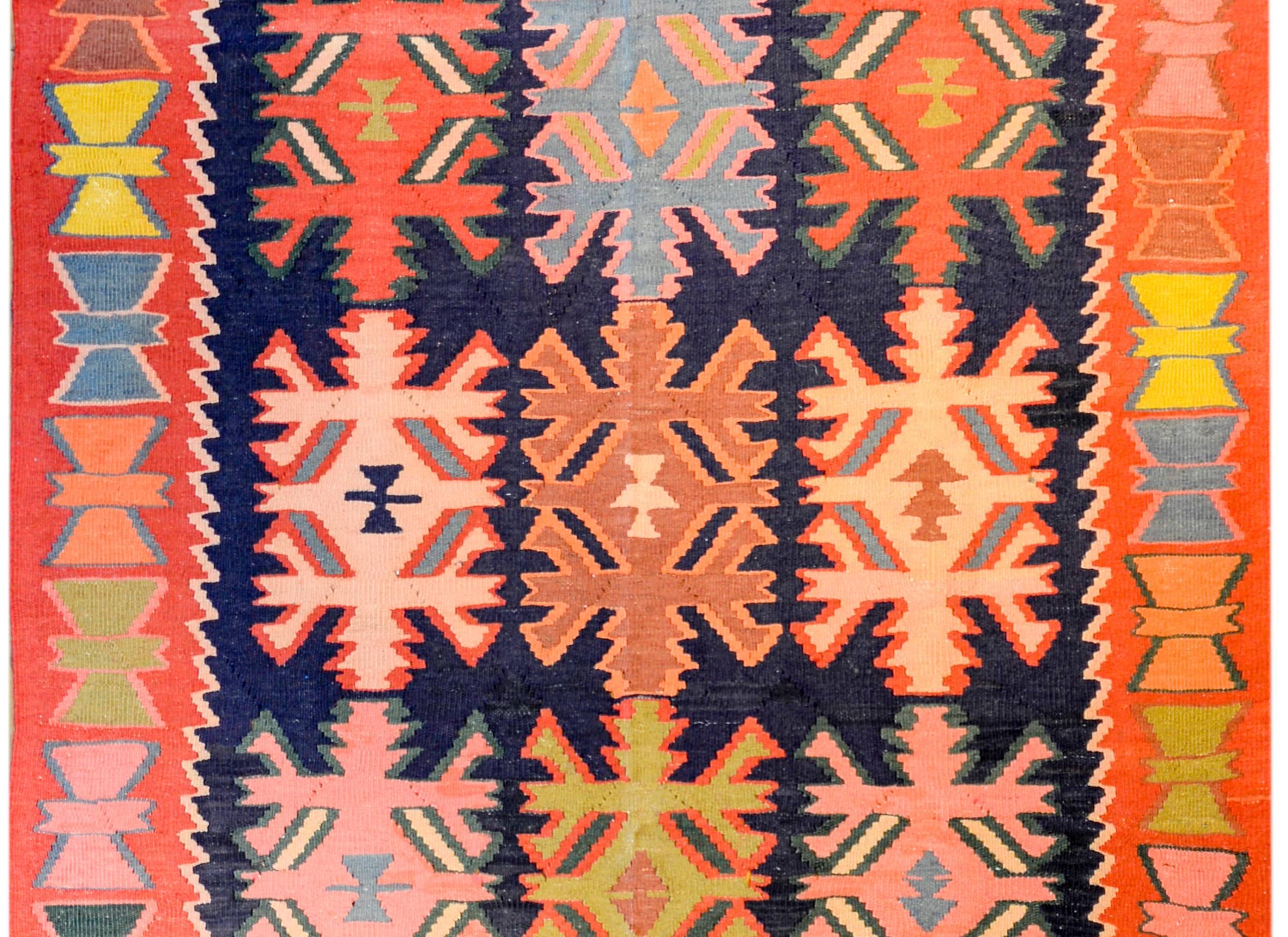A large early 20th century Persian Ersin Kilim runner with a fantastic bold geometric pattern woven on a beautiful dark indigo field, surrounded by a wonderful border with a wide crimson stripe with multicolored geometric shapes.