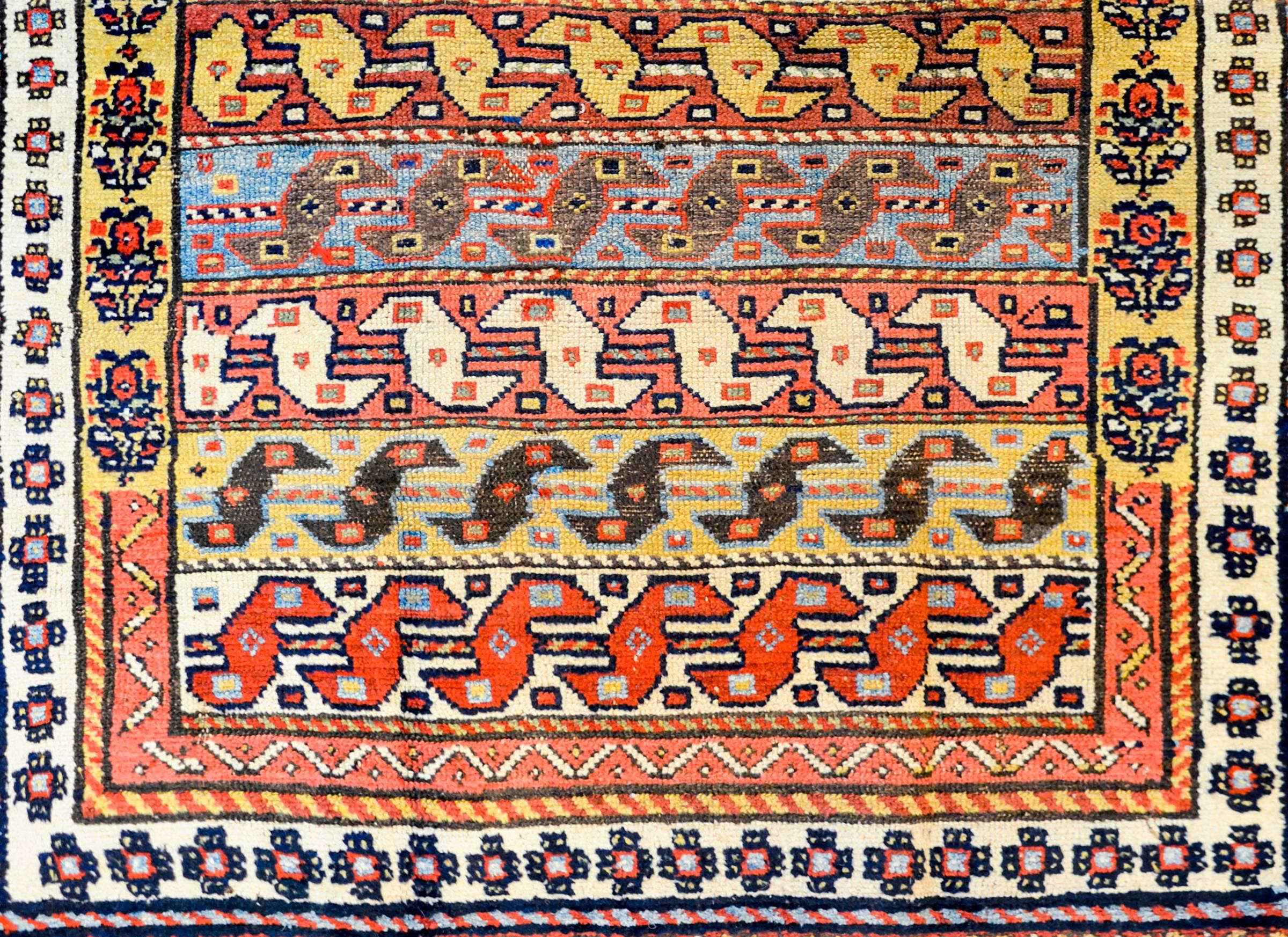 An extraordinary early 20th century Persian Kuba rug with a fantastic pattern of multicolored stripes, each with a stylized bird pattern across the entire field. The innermost border is wonderful, with a tree-of-life pattern on a gold background,