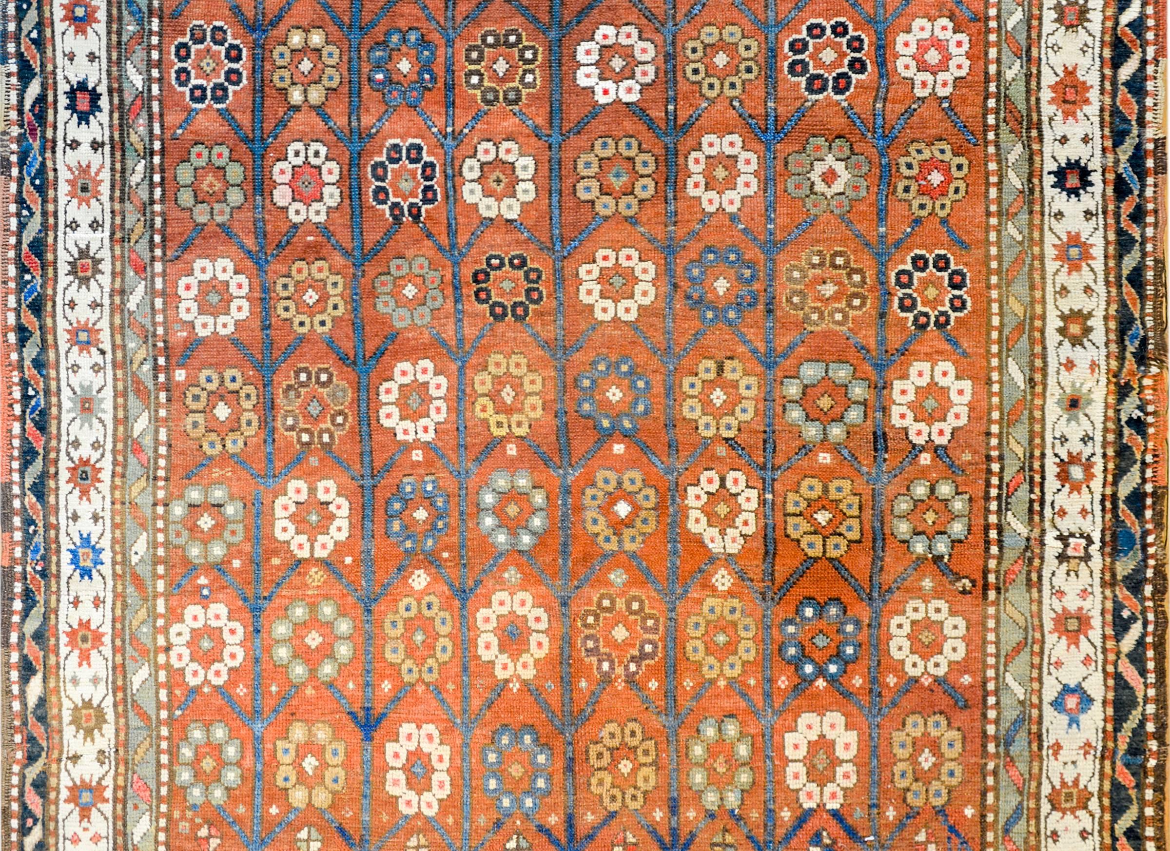 Unglaublicher Karabak-Teppich aus dem frühen 20. Jahrhundert mit einem großflächigen Blumen- und Rankenmuster aus heller und dunkler indigoblauer, goldener, weißer und brauner Wolle auf karminrotem Grund. Die Bordüre besteht aus mehreren
