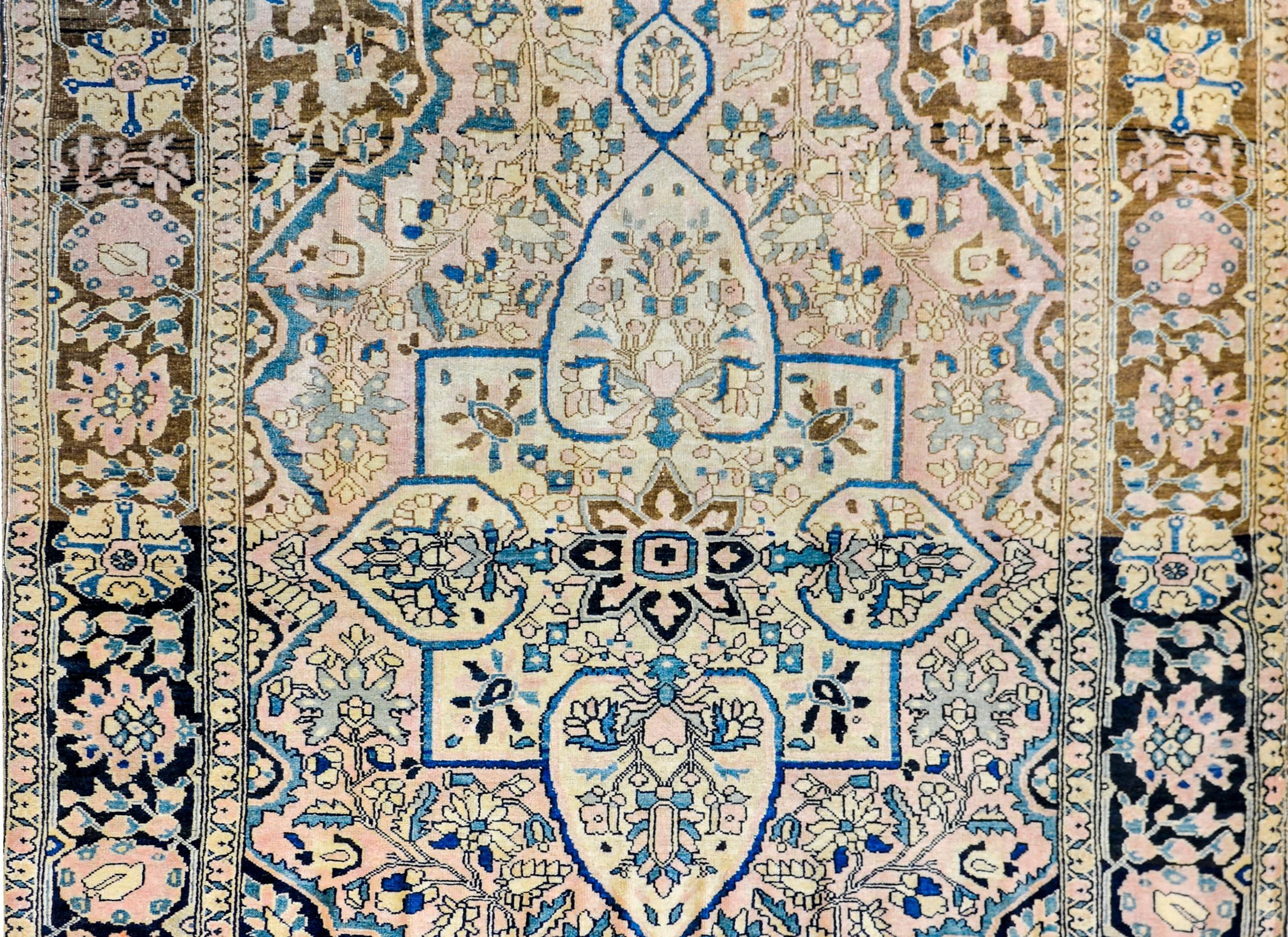 An amazing early 20th century Persian Sarouk Farahan rug with wonderfully woven large-scale floral medallion amidst a field of flowers woven in indigo, green, gold, and brown wool, on a natural, undyed, wool background surrounded by an elaborate