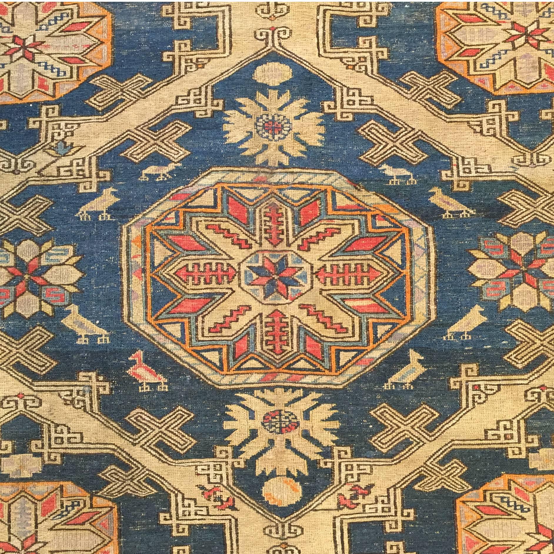 An early 20th century Persian Sumak rug with multiple beautiful medallions on an indigo background amidst a field of flowers, surrounded by multiple complementary floral borders.