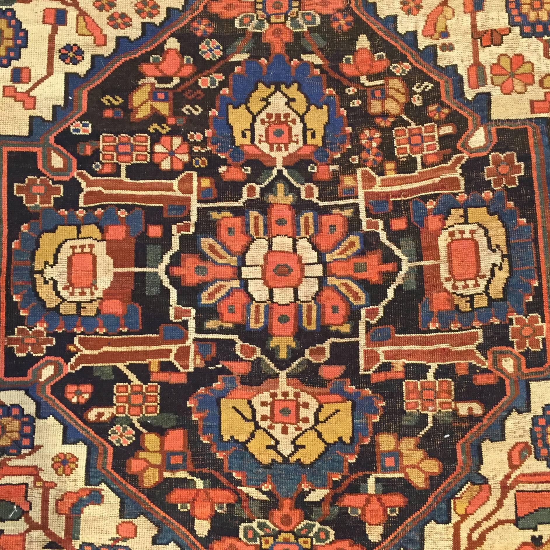 An early 20th century Persian Ghashghaei rug with an elaborate floral pattern and a sophisticated tribal hand.