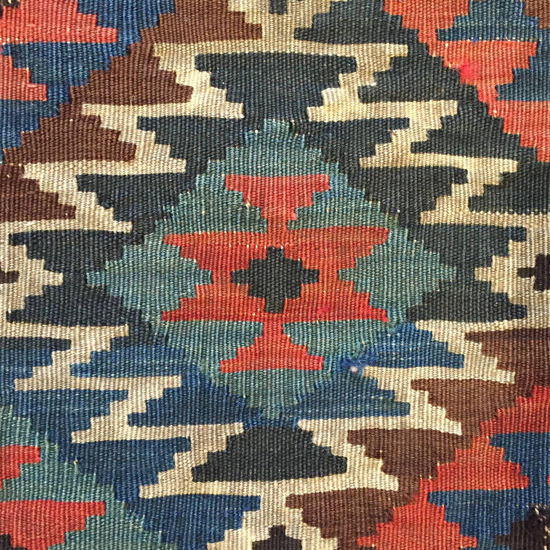 An early 20th century, Azerbaijani, Shahsavan Kilim rug with a traditional crimson, sage green and indigo diamond pattern with natural colored zig-zag diagonals, surrounded by a complimentary colored border.