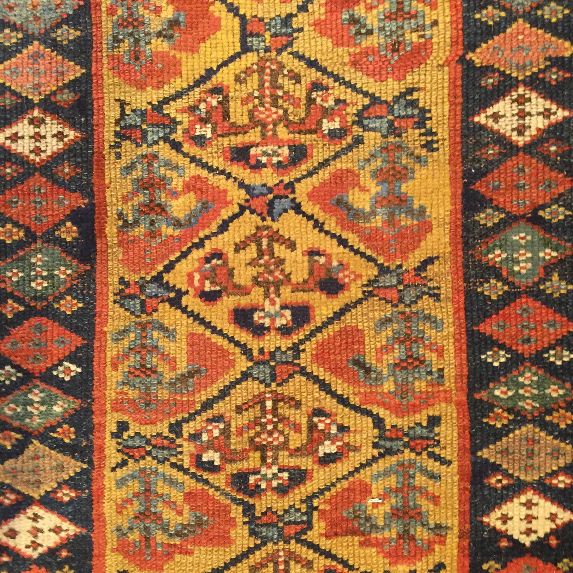 A wonderful late 19th century Persian Kurdish runner woven with wonderful natural vegetable dyed maize, crimson, and indigo dyes in an all-over tree-of-life diamond pattern surrounded by multiple intricately woven contrasting diamond and geometric