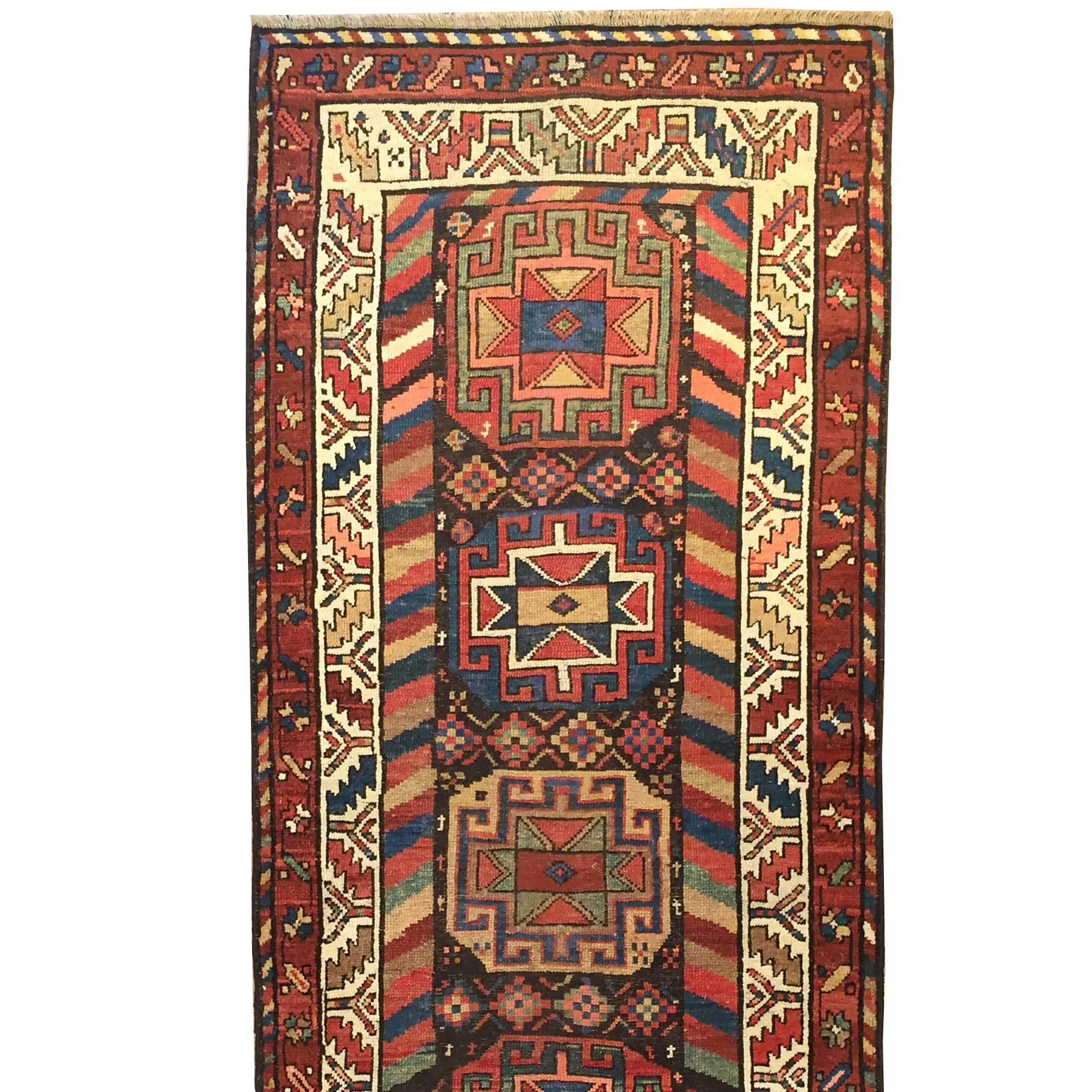 A late 19th century Persian Azeri runner with nine unique and wonderfully detailed multi-colored octagonal medallions with geometric designs in natural vegetable dyed crimson, indigo, emerald and saffron colors, surrounded by multiple complementary