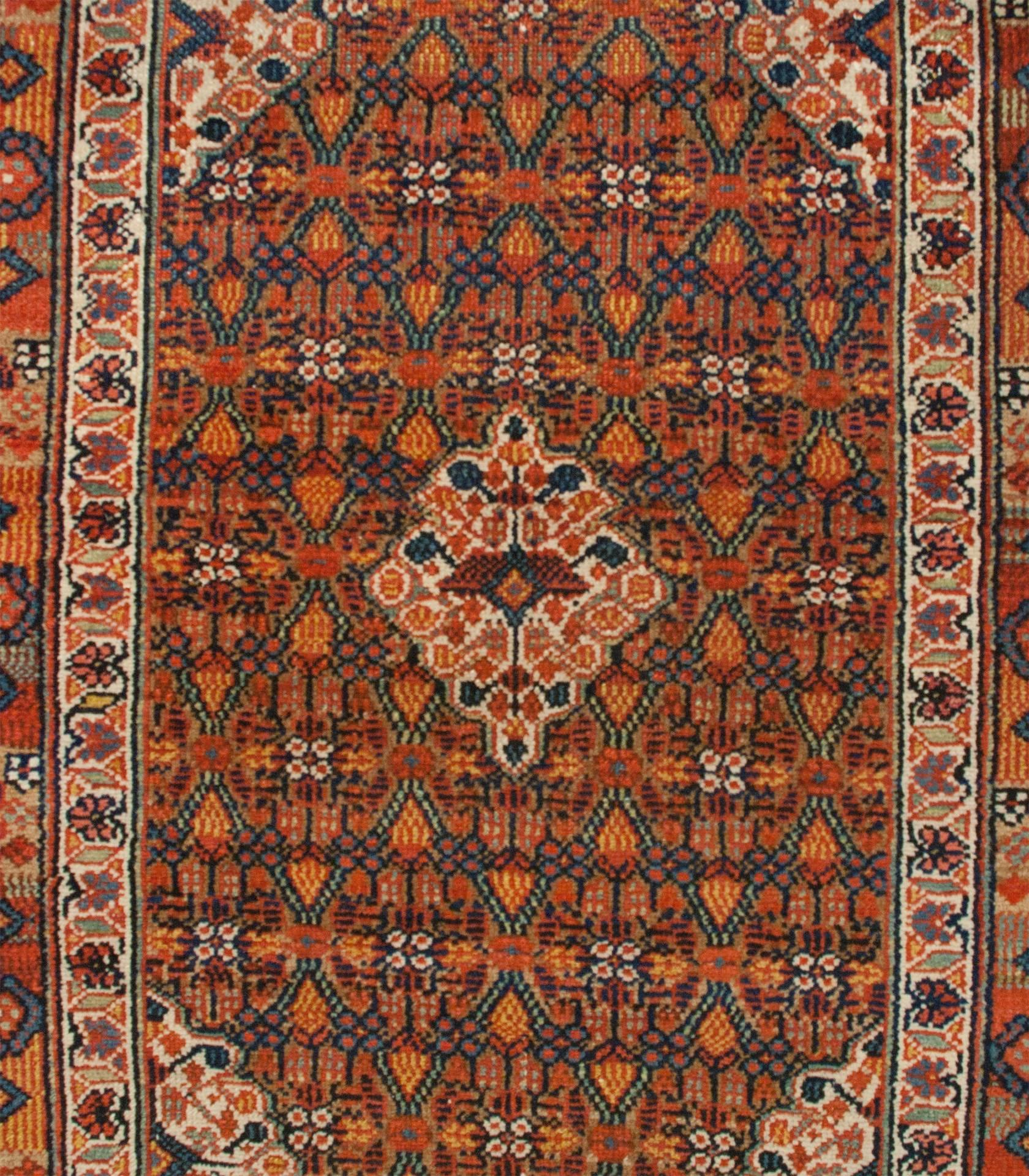 Étonnant tapis en poil de chameau Serab perse du XIXe siècle, avec un champ en treillis multicolore intensément tissé, entouré d'une bordure florale contrastée et d'une autre bordure géométrique multicolore, le tout entouré d'une bordure en poil de