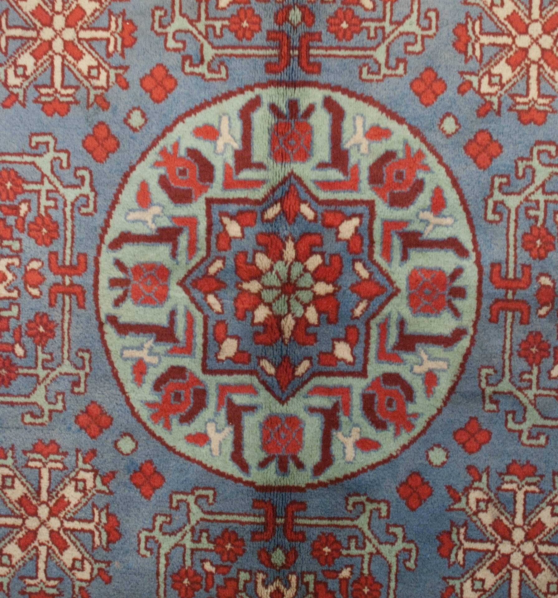 An unusual late 20th century central Asian Samarkand rug woven with multiple shades of indigo beginning with a large light-blue central medallion with a stylized pomegranate motif, on a larger dark-blue field with multiple floral and geometric