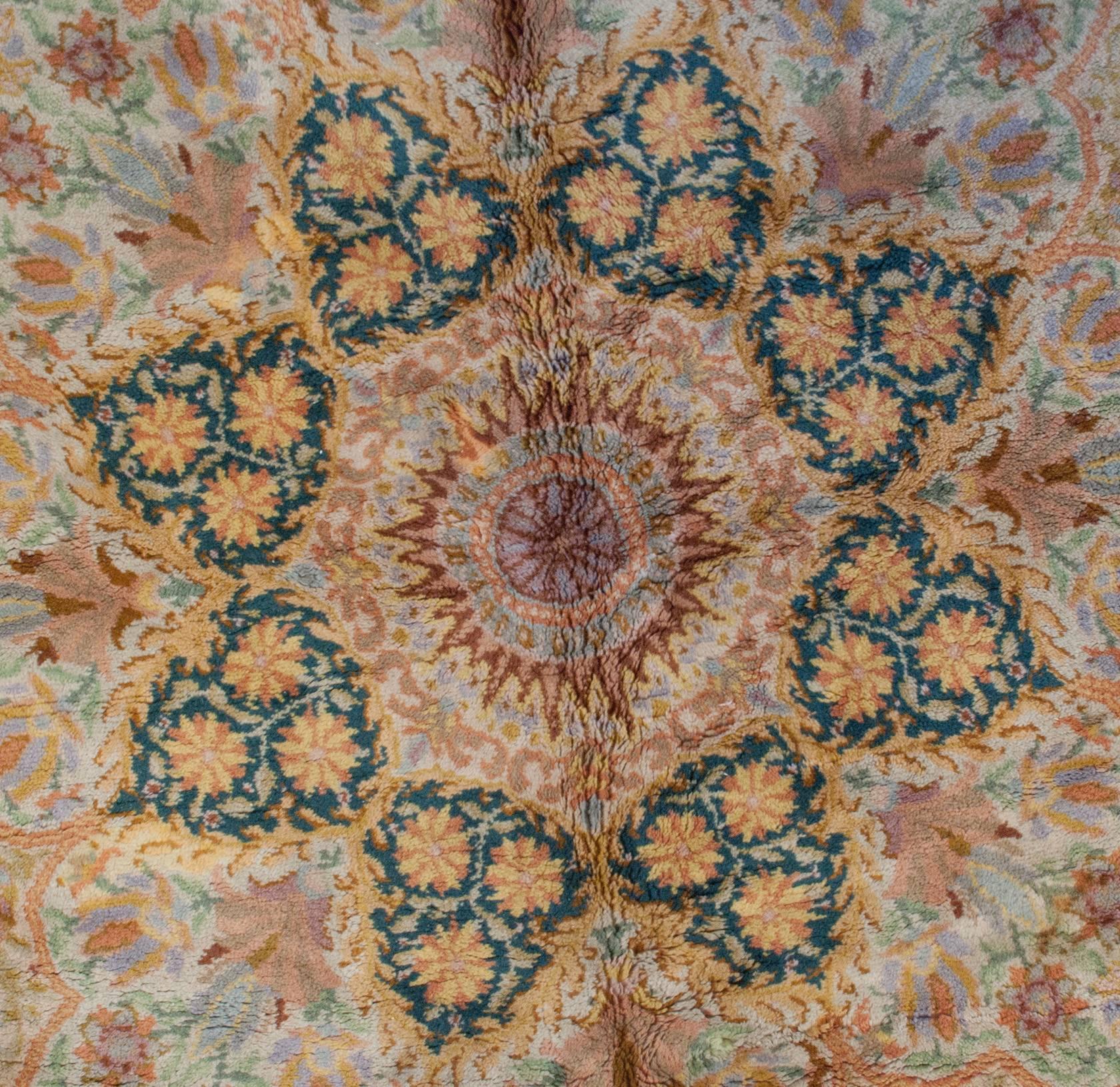 An unusual mid-20th century German rug with a beautifully and intensely woven Persian-inspired pattern with multiple stacked medallions radiating out of the center in hues of taupe, pale indigo, green, gold and orange. Each medallion is its own