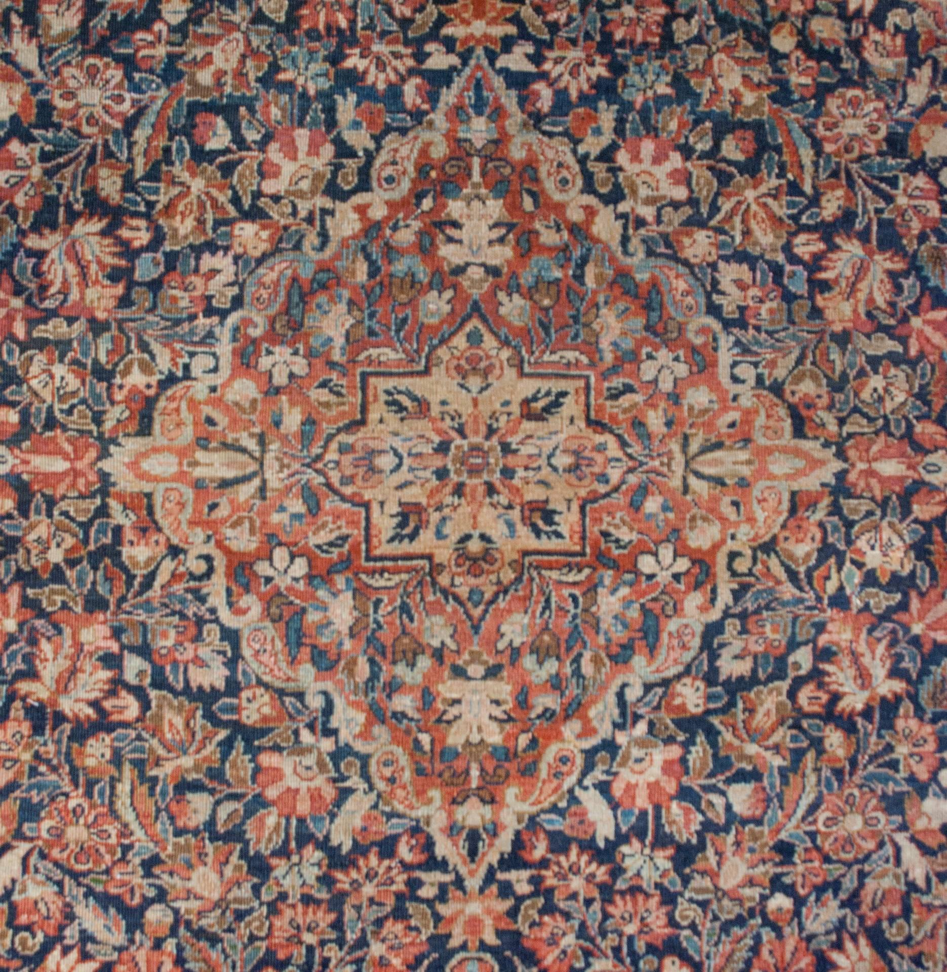 An amazing late 19th century Persian Tabriz rug with an intensely woven multicolored floral pattern in crimson, indigo, turquoise and natural undyed wool with a large central diamond shaped medallion amidst a field of multi-species flowers
