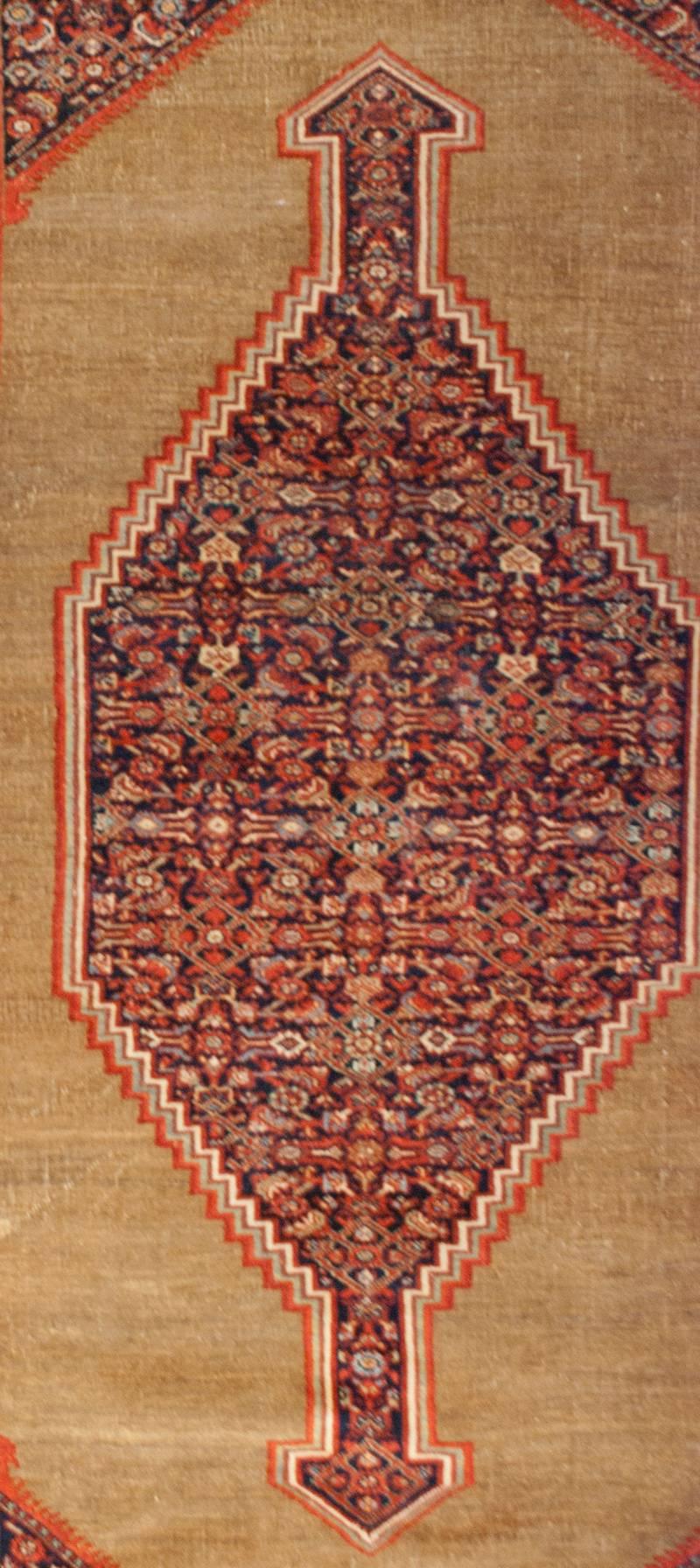 A gorgeous 19th century Persian Farahan rug with a beautiful diamond medallion with an elaborately woven floral and vine and diamond medallion woven in crimson and indigo dyed wool, surrounded by a large field of camel hair wool surrounded by