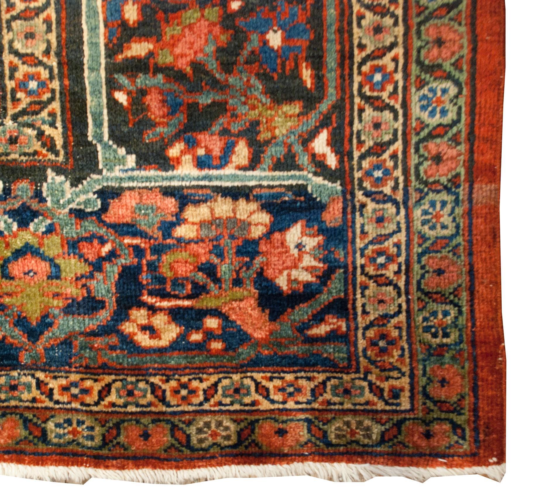 An extraordinary early 20th century Persian Mahal rug with an amazing all-over pattern of multicolored flowers in a wonderful lattice pattern on a crimson background. The wide border is composed with scrolling vines criss-crossing a garden of